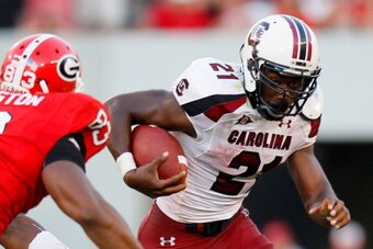 ATHENS, GA - SEPTEMBER 10:  Marcus Lattimore #21 of the South Carolina Gamecocks rushes upfield against Cornelius Washington #83 of the Georgia Bulldogs at Sanford Stadium on September 10, 2011 in Athens, Georgia.  (Photo by Kevin C. Cox/Getty Images)