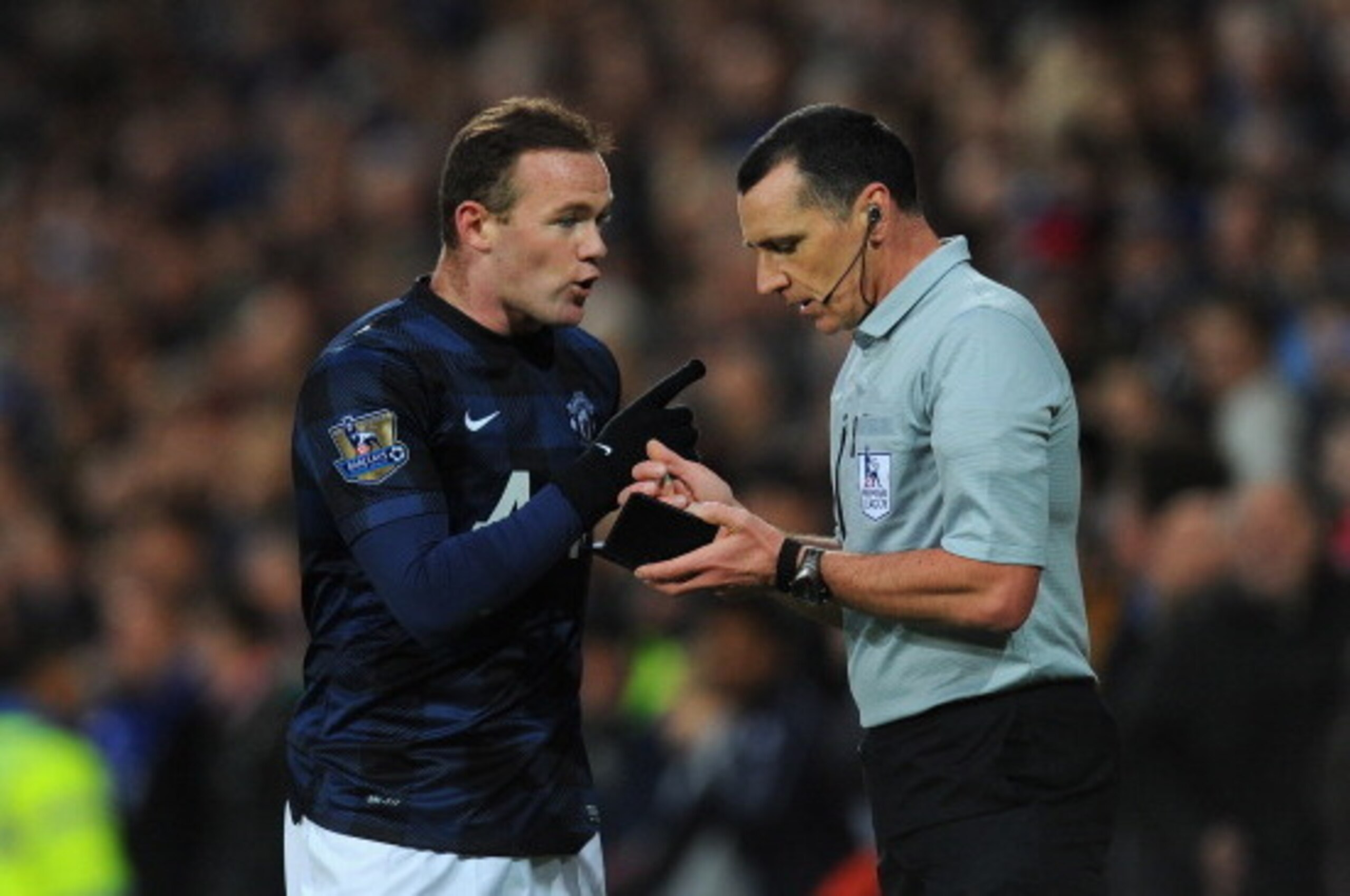 CARDIFF, WALES - NOVEMBER 24:  Manchester United player Wayne Rooney (l) makes a point to referee Neil Swarbrick after being booked during the Barclays Premier League match between Cardiff City and Manchester United at Cardiff City Stadium on November 24,