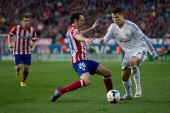 MADRID, SPAIN - MARCH 02: Cristiano Ronaldo (R) of Real Madrid CF competes for the ball with Juan Francisco Torres alias Juanfran (L) of Atletico de Madrid during the La Liga match between Club Atletico de Madrid and Real Madrid CF at Vicente Calderon Sta