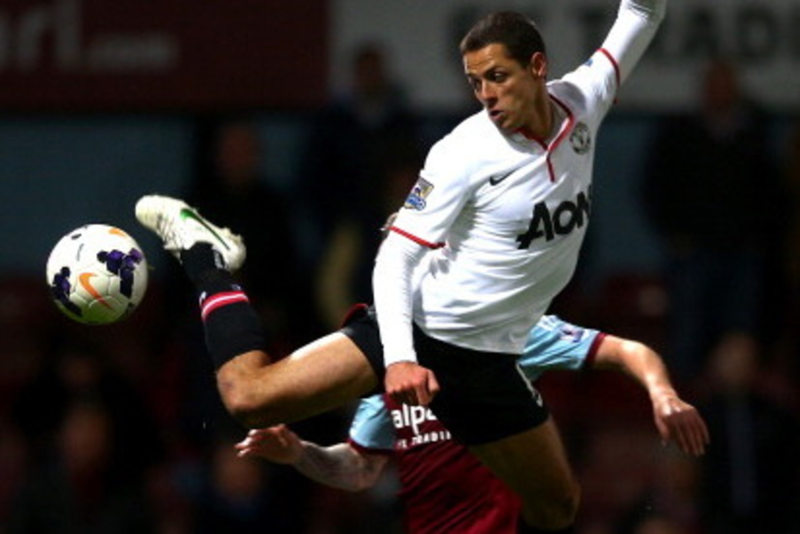LONDON, ENGLAND - MARCH 22:  Javier Hernandez of Manchester United competes for the ball with George McCartney of West Ham during the Barclays Premier League match between West Ham United and Manchester United at Boleyn Ground on March 22, 2014 in London,