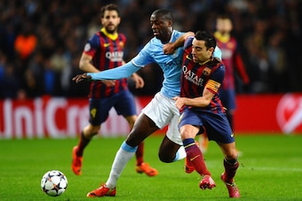 MANCHESTER, ENGLAND - FEBRUARY 18:  Xavi Hernandez of Barcelona battles with Yaya Toure of Manchester City during the UEFA Champions League Round of 16 first leg match between Manchester City and Barcelona at the Etihad Stadium on February 18, 2014 in Man