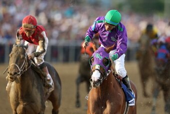BALTIMORE, MD - MAY 17:  California Chrome #3, ridden by Victor Espinoza, races accross the finishline to win the 139th running of the Preakness Stakes at Pimlico Race Course on May 17, 2014 in Baltimore, Maryland.  (Photo by Matthew Stockman/Getty Images