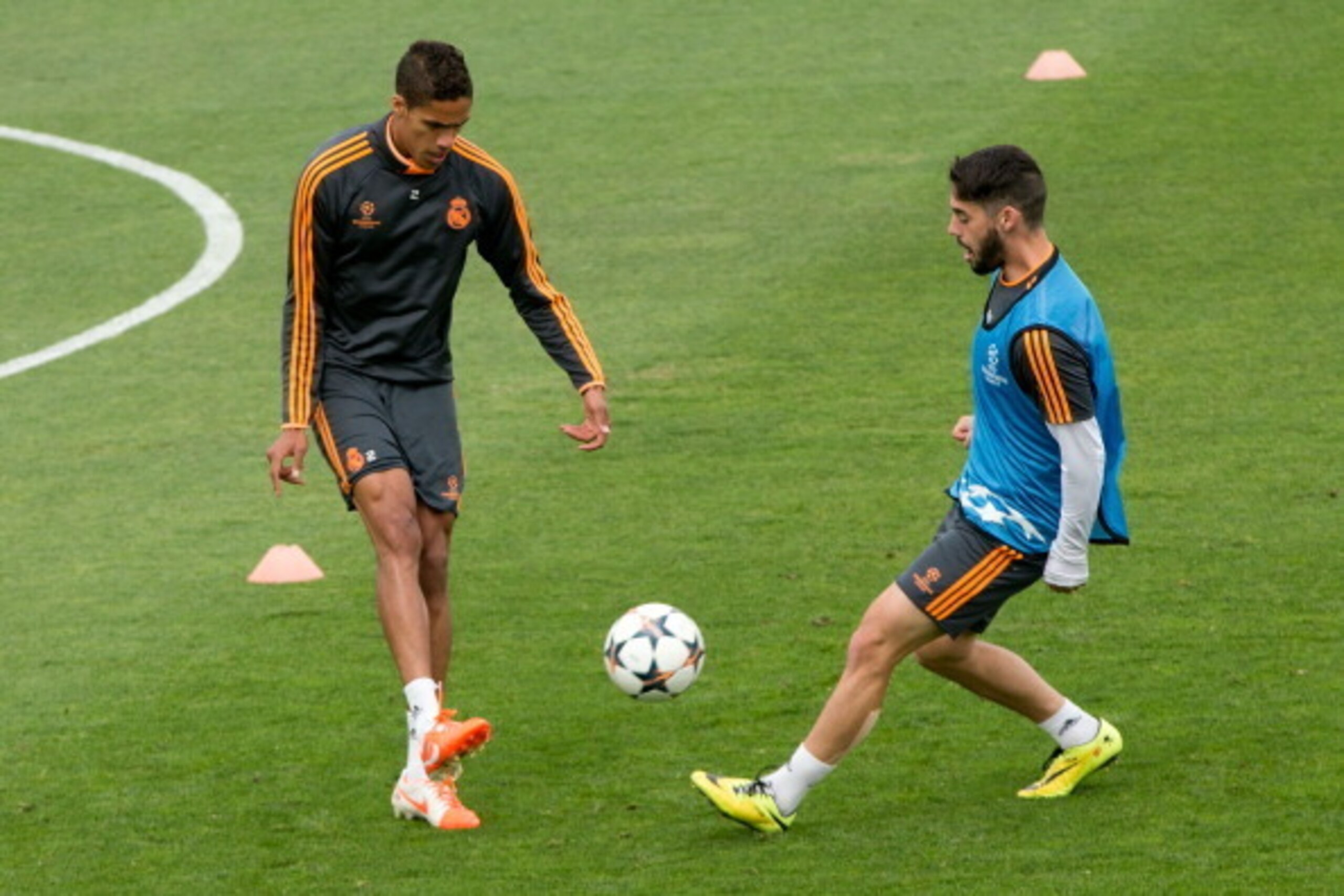 MADRID, SPAIN - MAY 20: Francisco Roman Alarcon alias Isco (R) of Real Madrid CF competes for the ball with his teammate Raphael Varane (L) during the training session held the Real Madrid media day, prior to UEFA Champions League final against Club Atlet