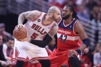 Apr 20, 2014; Chicago, IL, USA; Chicago Bulls forward Carlos Boozer (5) is defended by Washington Wizards forward Nene Hilario (42) during the first quarter of game one of the first round of the 2014 NBA Playoffs at the United Center. Mandatory Credit: De
