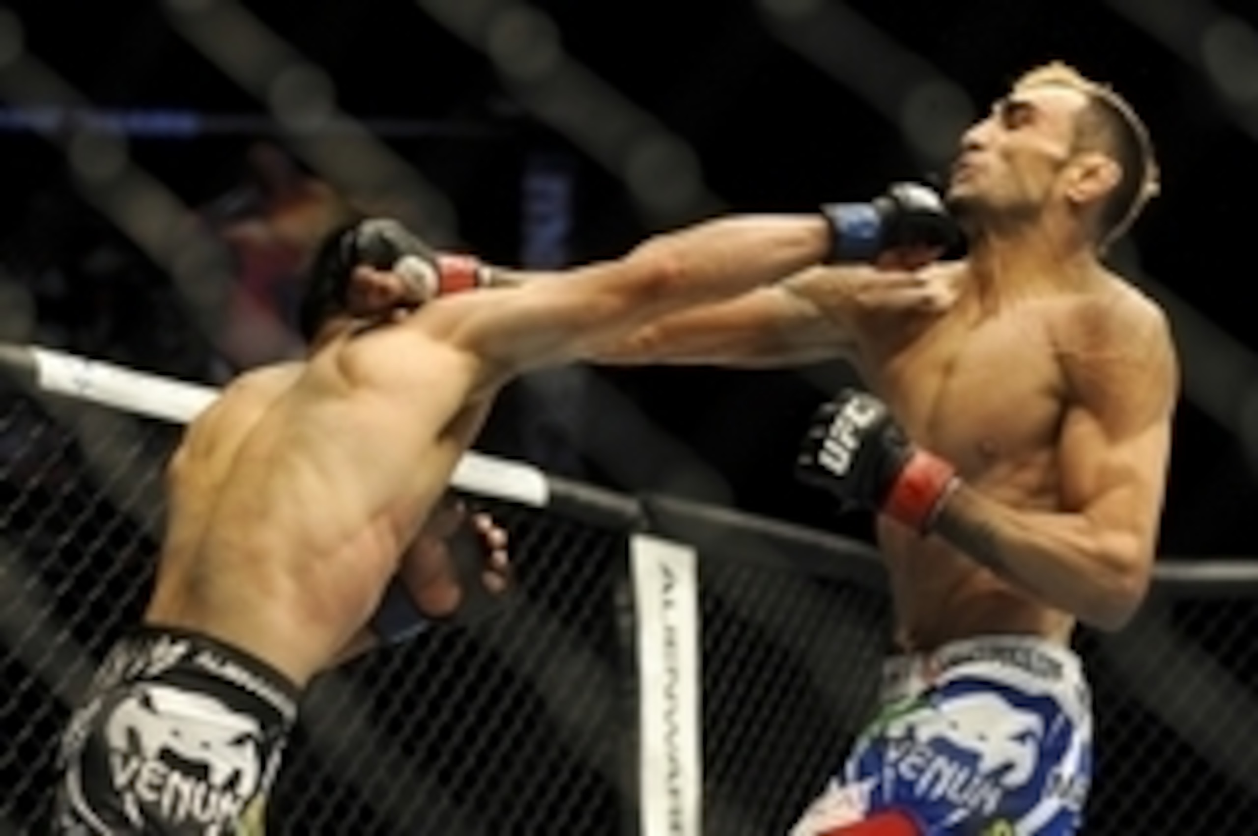 May 24, 2014; Las Vegas, NV, USA; Tony Ferguson (red) and Katsunori Kikuno (blue) throw punches during their UFC 173 welterweight bout at MGM Grand Garden Arena. Ferguson won the bout by TKO. Mandatory Credit: Stephen R. Sylvanie-USA TODAY Sports