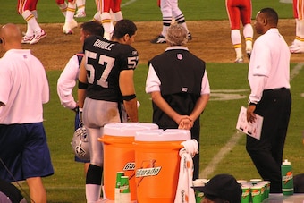 On the sideline talking with the head trainer for the Raiders.