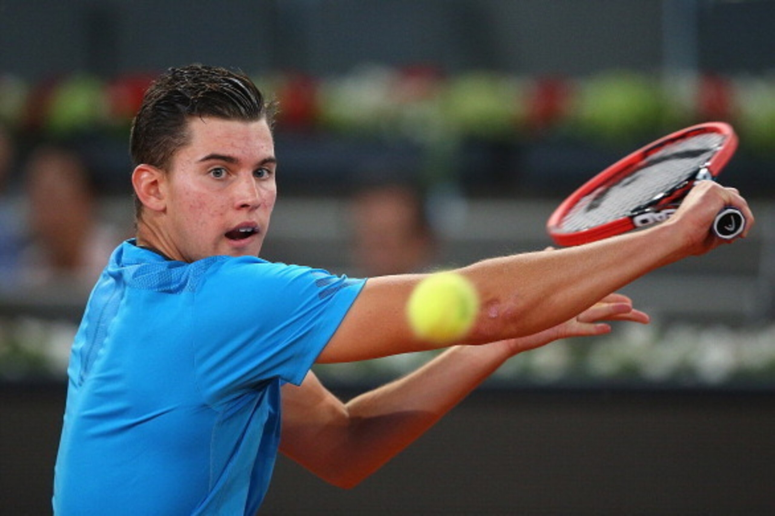 MADRID, SPAIN - MAY 06: Dominic Thiem of Austria plays a backhand against Stanislas Wawrinka of Switzerland in their second round match during day four of the Mutua Madrid Open tennis tournament at the Caja Magica on May 6, 2014 in Madrid, Spain. (Photo MADRID, SPAIN - MAY 06: Dominic Thiem of Austria plays a backhand against Stanislas Wawrinka of Switzerland in their second round match during day four of the Mutua Madrid Open tennis tournament at the Caja Magica on May 6, 2014 in Madrid, Spain. (Photo
