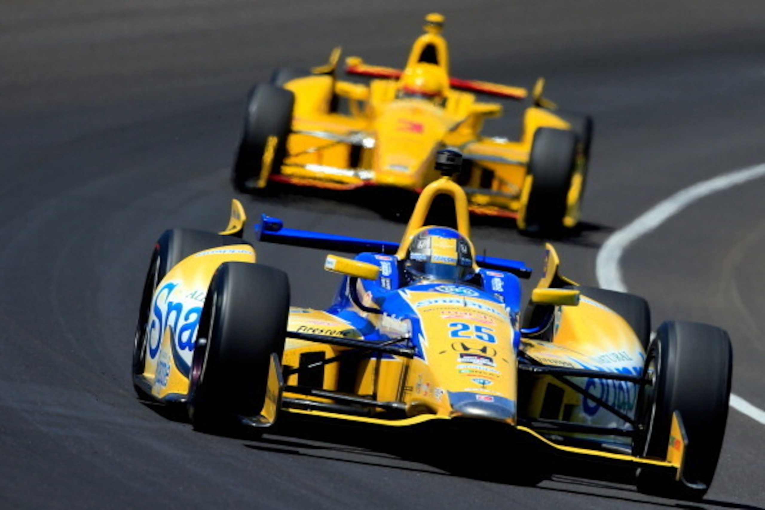 INDIANAPOLIS, IN - MAY 25: Marco Andretti, driver of the #25 Snapple Andretti Autosport Honda Dallara, leads Helio Castroneves of Brazil, driver of the #3 Pennzoil Ultra Platinum Penske Chevrolet Dallara, during the 98th running of the Indianapolis 500 at