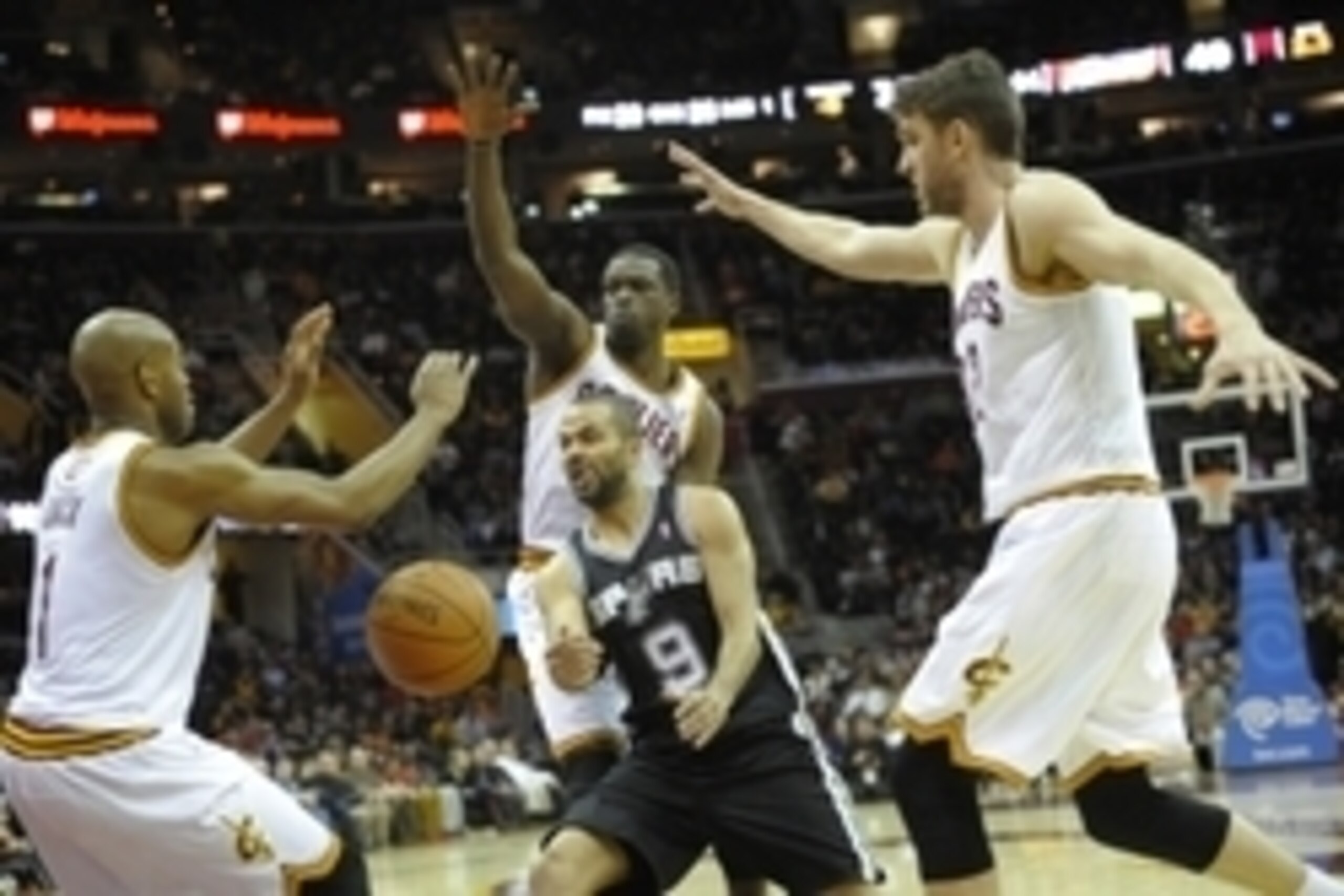 Mar 4, 2014; Cleveland, OH, USA; San Antonio Spurs point guard Tony Parker (9) passes against Cleveland Cavaliers point guard Jarrett Jack (1), small forward Luol Deng (back center) and center Spencer Hawes (32) in the third quarter at Quicken Loans Arena