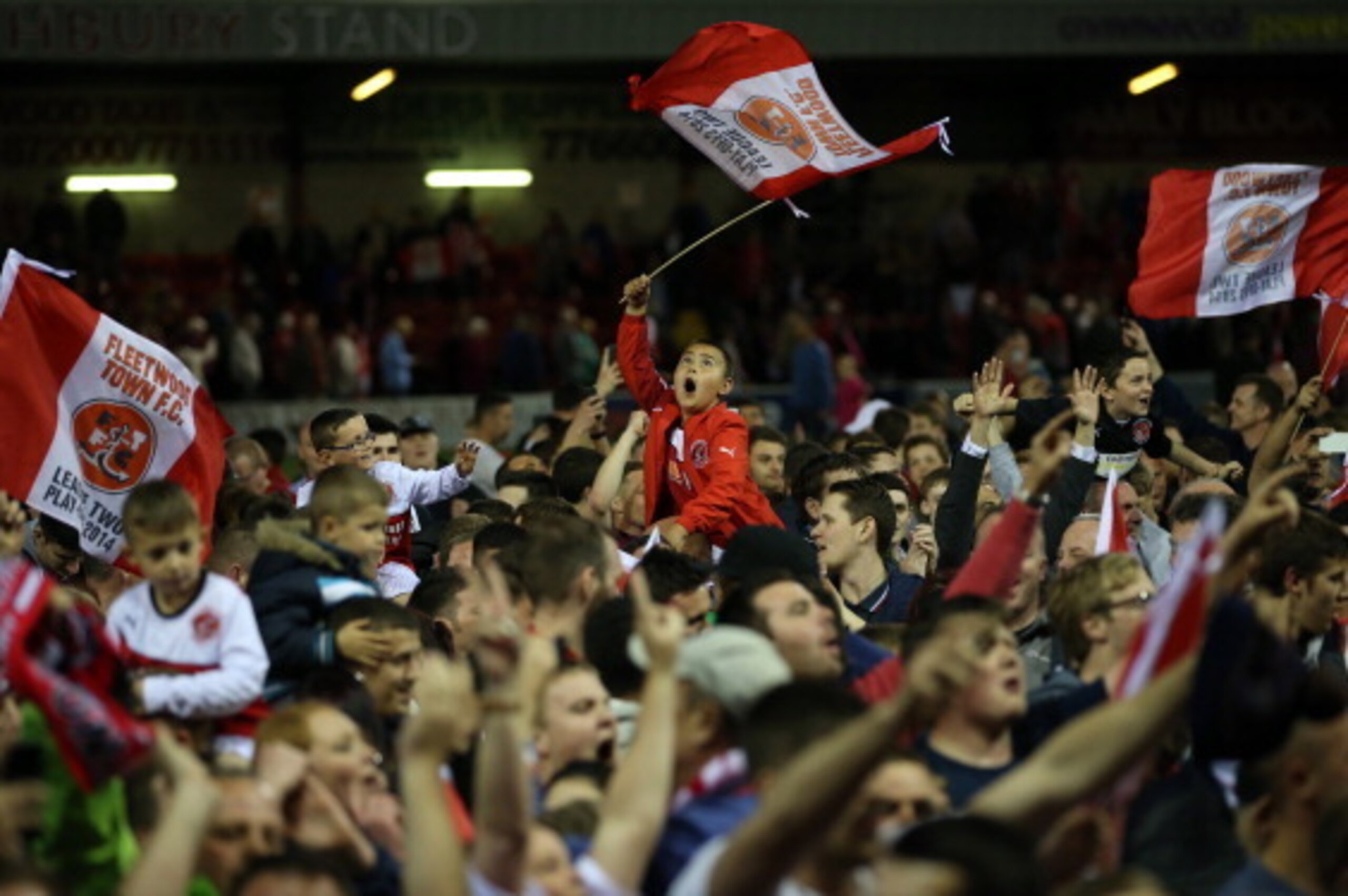 FLEETWOOD, ENGLAND - MAY 16:  Fleetwood fans celebrate at the final whistle during the Sky Bet League Two play off Semi Final second leg match between Fleetwood Town and York City at Highbury Stadium on May 16, 2014 in Fleetwood, England.  (Photo by Jan K