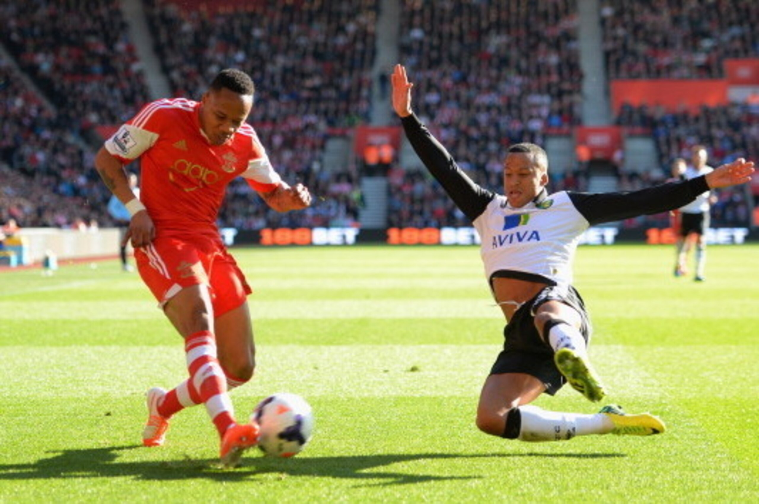 SOUTHAMPTON, ENGLAND - MARCH 15:  Nathaniel Clyne of Southampton puts a cross in as Martin Olsson of Norwich dives in during the Barclays Premier League match between Southampton and Norwich City at St Mary's Stadium on March 15, 2014 in Southampton, Engl