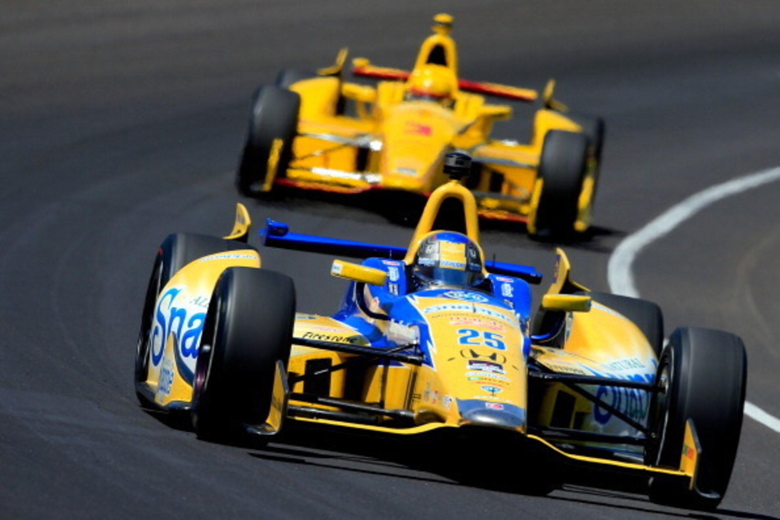 INDIANAPOLIS, IN - MAY 25: Marco Andretti, driver of the #25 Snapple Andretti Autosport Honda Dallara, leads Helio Castroneves of Brazil, driver of the #3 Pennzoil Ultra Platinum Penske Chevrolet Dallara, during the 98th running of the Indianapolis 500 at
