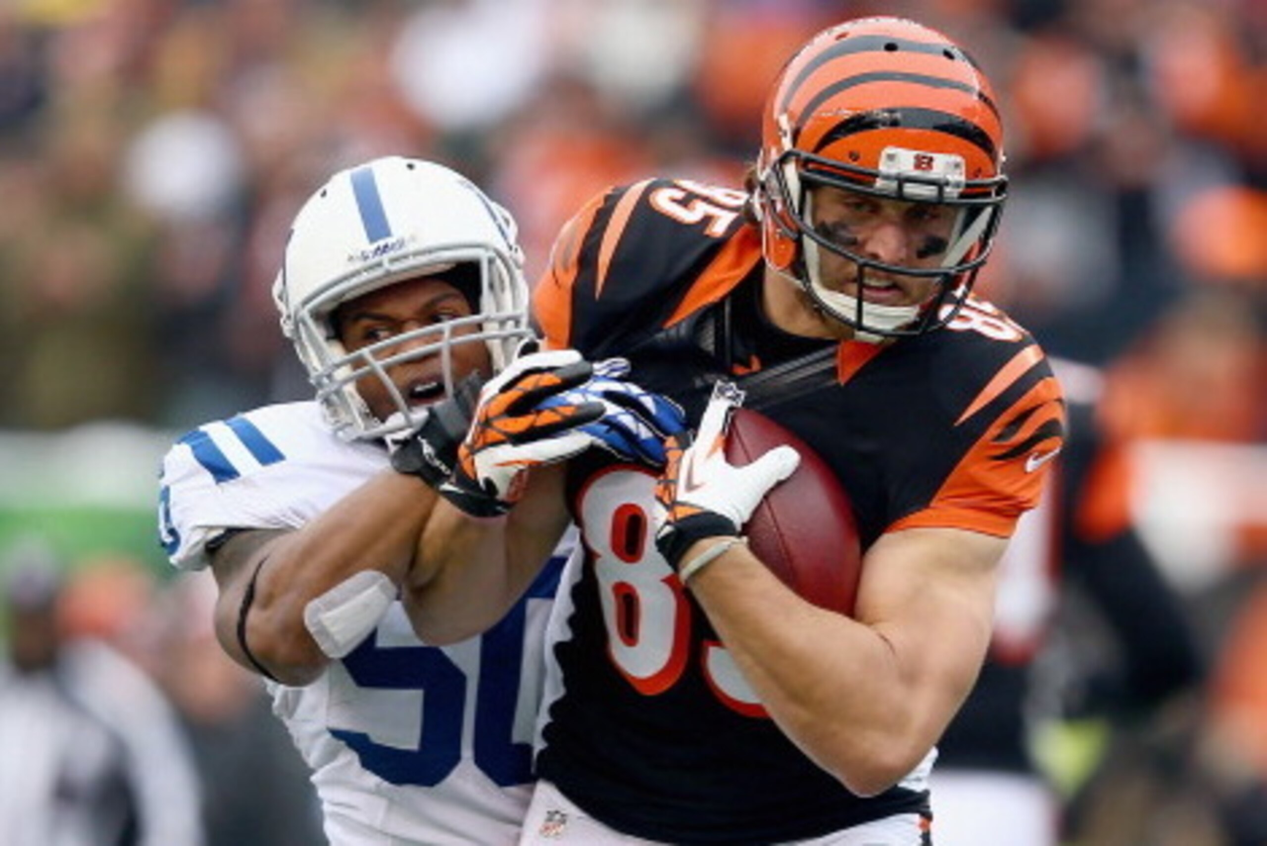 CINCINNATI, OH - DECEMBER 08: Tyler Eifert #85 of the Cincinnati Bengals runs with the ball while defended by Jerrell Freeman #50 of the Indianapolis Colts during the NFL game at Paul Brown Stadium on December 8, 2013 in Cincinnati, Ohio.  (Photo by Andy