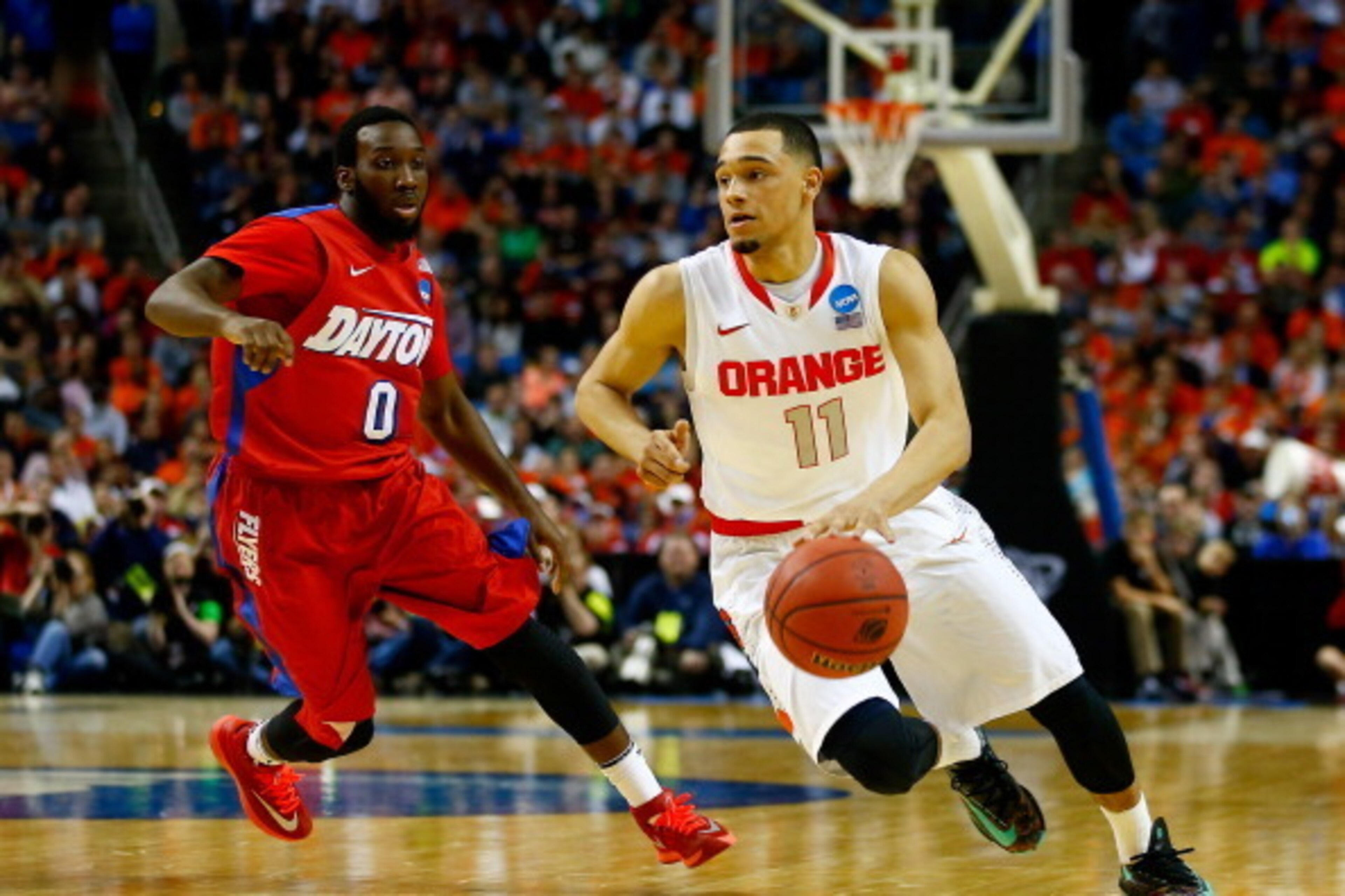 BUFFALO, NY - MARCH 22: Tyler Ennis #11 of the Syracuse Orange drives to the basket as Khari Price #0 of the Dayton Flyers defends during the third round of the 2014 NCAA Men's Basketball Tournament at the First Niagara Center on March 22, 2014 in Buffalo
