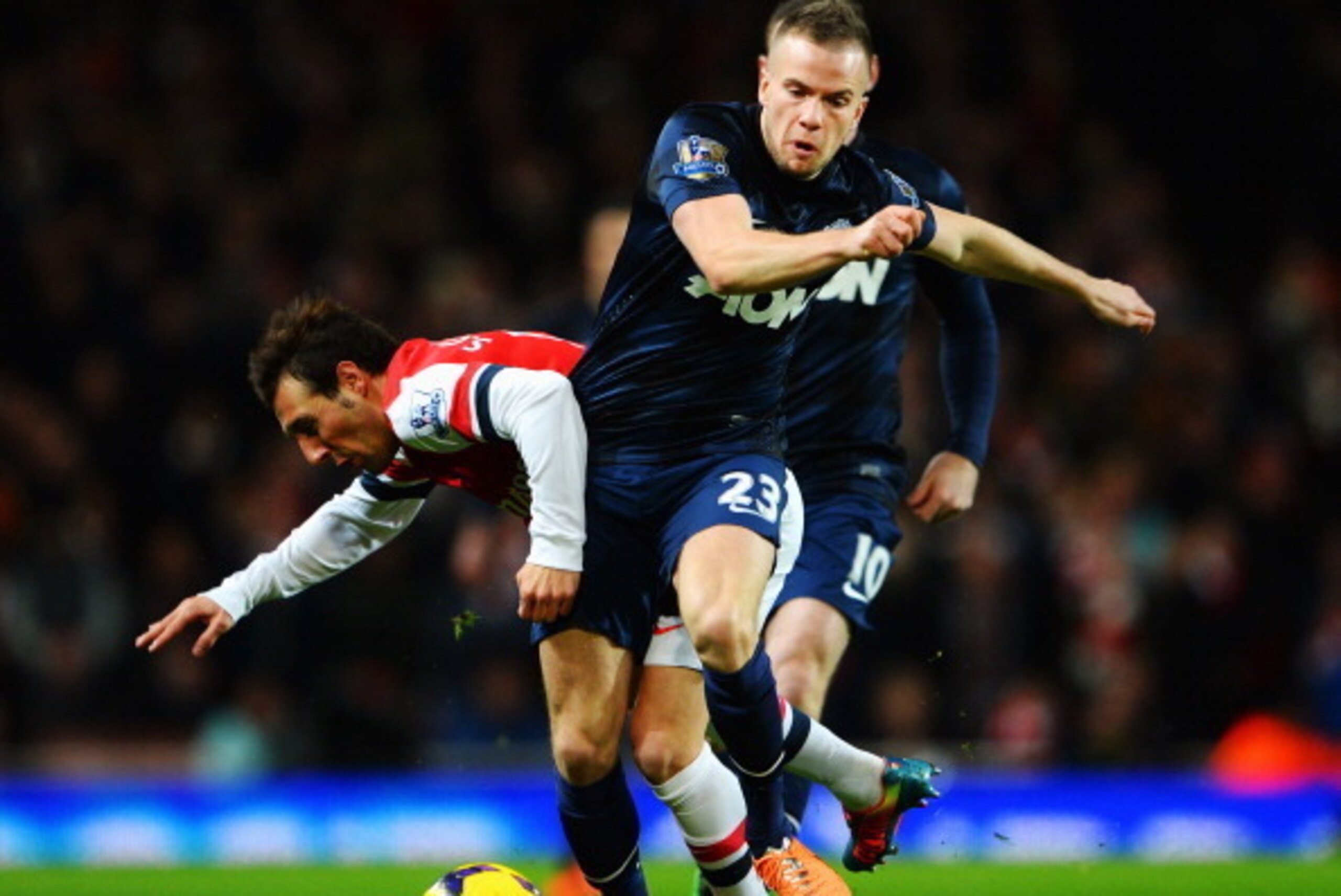 LONDON, ENGLAND - FEBRUARY 12:  Santi Cazorla (L) of Arsenal is challenged by Tom Cleverley (R) of Manchester United during the Barclays Premier League match between Arsenal and Manchester United at the Emirates Stadium on February 12, 2014 in London, Eng