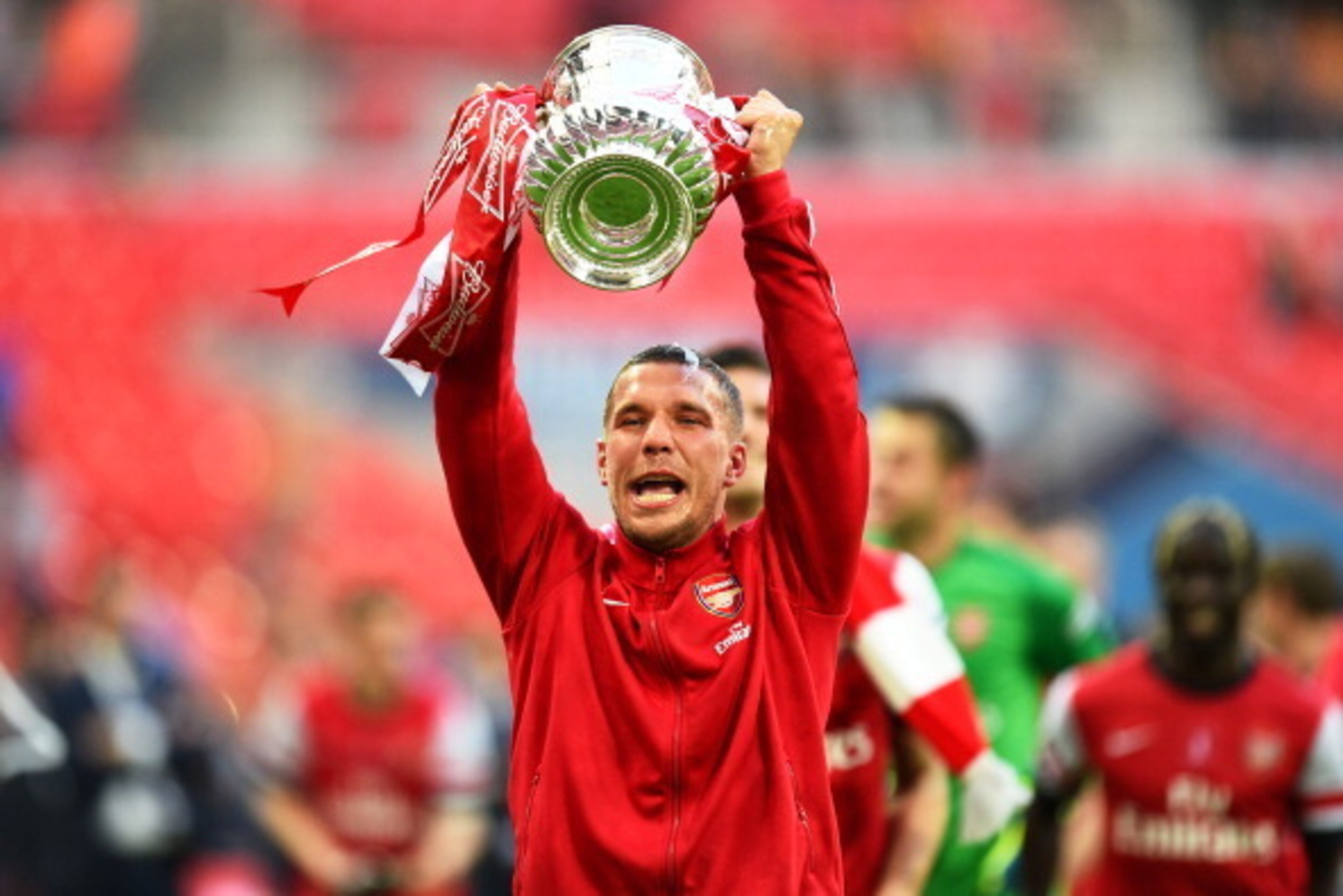 LONDON, ENGLAND - MAY 17:  Lukas Podolski of Arsenal celebrates victory with the trophy after the FA Cup with Budweiser Final match between Arsenal and Hull City at Wembley Stadium on May 17, 2014 in London, England.  (Photo by Shaun Botterill/Getty Image