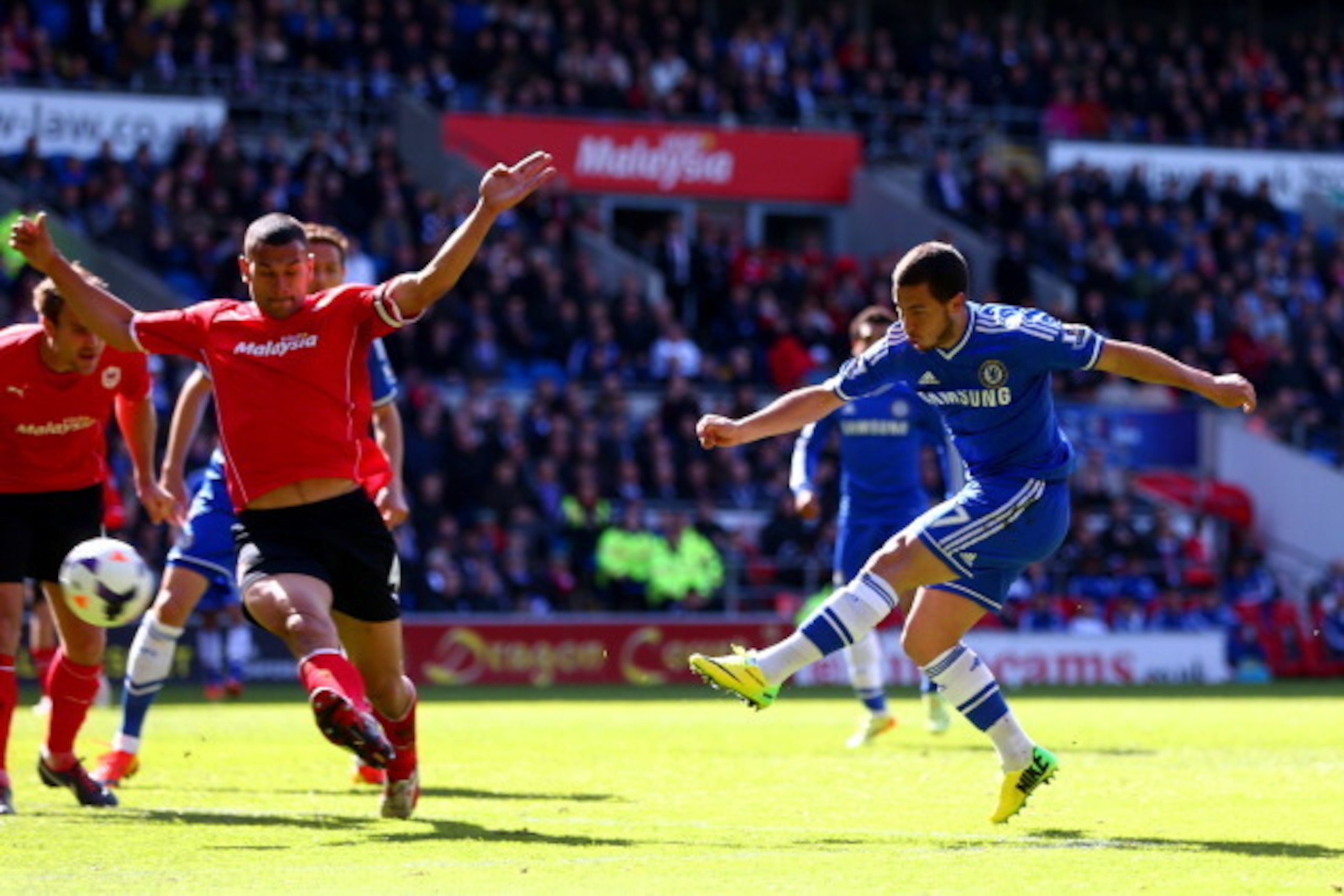 CARDIFF, WALES - MAY 11:  Eden Hazard of Chelsea shoots past Steven Caulker of Cardiff City during the Barclays Premier League match between Cardiff City and Chelsea at Cardiff City Stadium on May 11, 2014 in Cardiff, Wales.  (Photo by Michael Steele/Gett