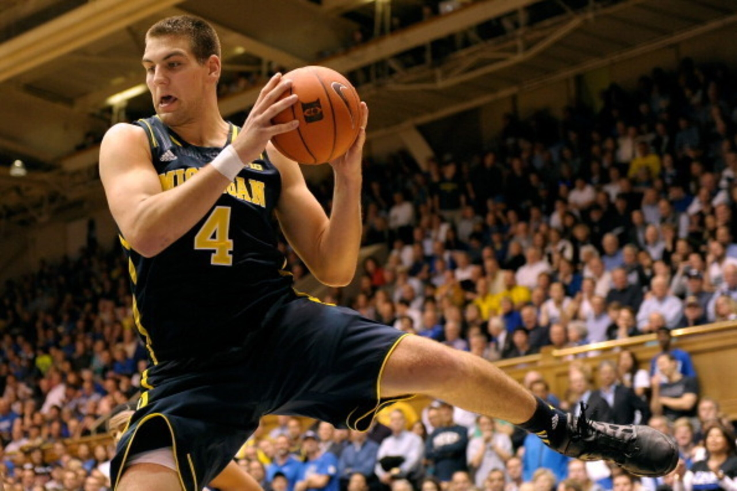 DURHAM, NC - DECEMBER 03:  Mitch McGary #4 of the Michigan Wolverines pulls down a rebound against the Duke Blue Devils at Cameron Indoor Stadium on December 3, 2013 in Durham, North Carolina. Duke won 79-69.  (Photo by Grant Halverson/Getty Images)