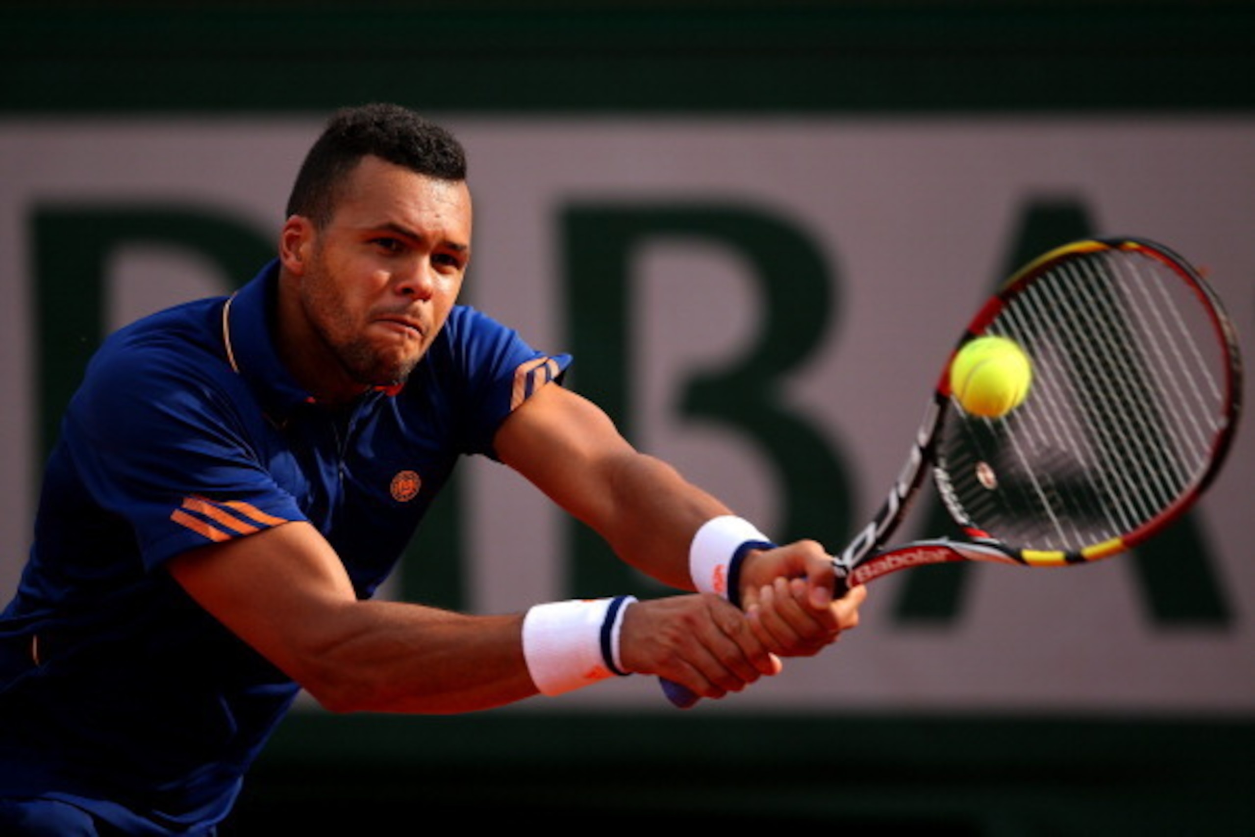 PARIS, FRANCE - MAY 25:  Jo-Wilfried Tsonga of France returns a shot during his men's singles match against  Edouard Roger-Vasselin of France on day one of the French Open at Roland Garros on May 25, 2014 in Paris, France.  (Photo by Clive Brunskill/Getty
