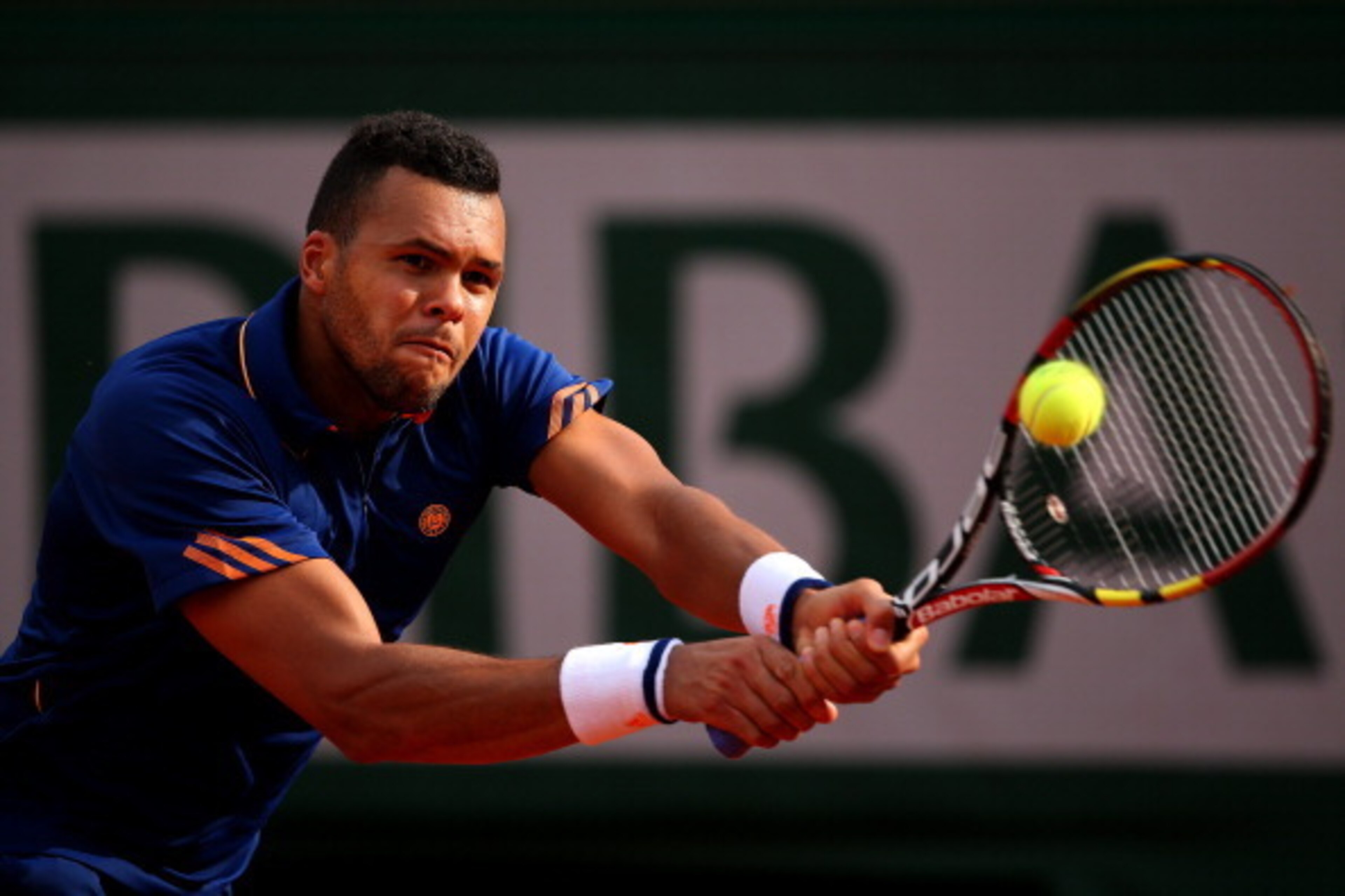 PARIS, FRANCE - MAY 25:  Jo-Wilfried Tsonga of France returns a shot during his men's singles match against  Edouard Roger-Vasselin of France on day one of the French Open at Roland Garros on May 25, 2014 in Paris, France.  (Photo by Clive Brunskill/Getty