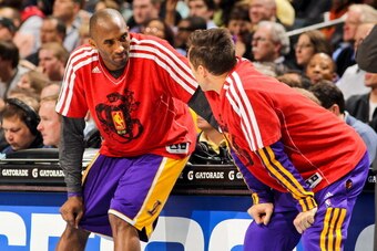 CHARLOTTE, NC - FEBRUARY 8: Kobe Bryant #24 and Steve Nash #10 of the Los Angeles Lakers, wearing shirts in honor of Chinese New Year, wait to check into a game against the Charlotte Bobcats at Time Warner Cable Arena on February 8, 2013 in Charlotte, Nor