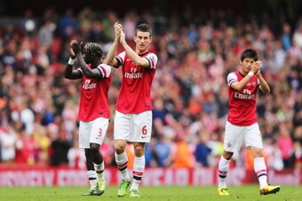 LONDON, ENGLAND - SEPTEMBER 22:  (L-R) Bacary Sagna, Laurent Koscielny and Ryo Miyaichi of Arsenal celebrate victory after the Barclays Premier League match between Arsenal and Stoke City at Emirates Stadium on September 22, 2013 in London, England.  (Pho