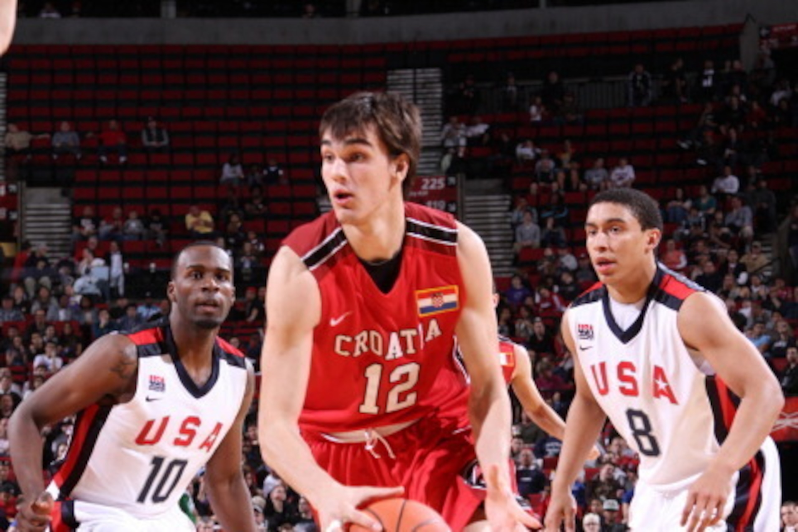 PORTLAND, OR - APRIL 7: Dario Saric #12 of the World Select Team drives against Shabazz Muhammad #10 and James Robinson #8 of the USA Junior Select Team during the 2012 Hoop Summit on April 7, 2012 at the Rose Garden Arena in Portland, Oregon. NOTE TO USE