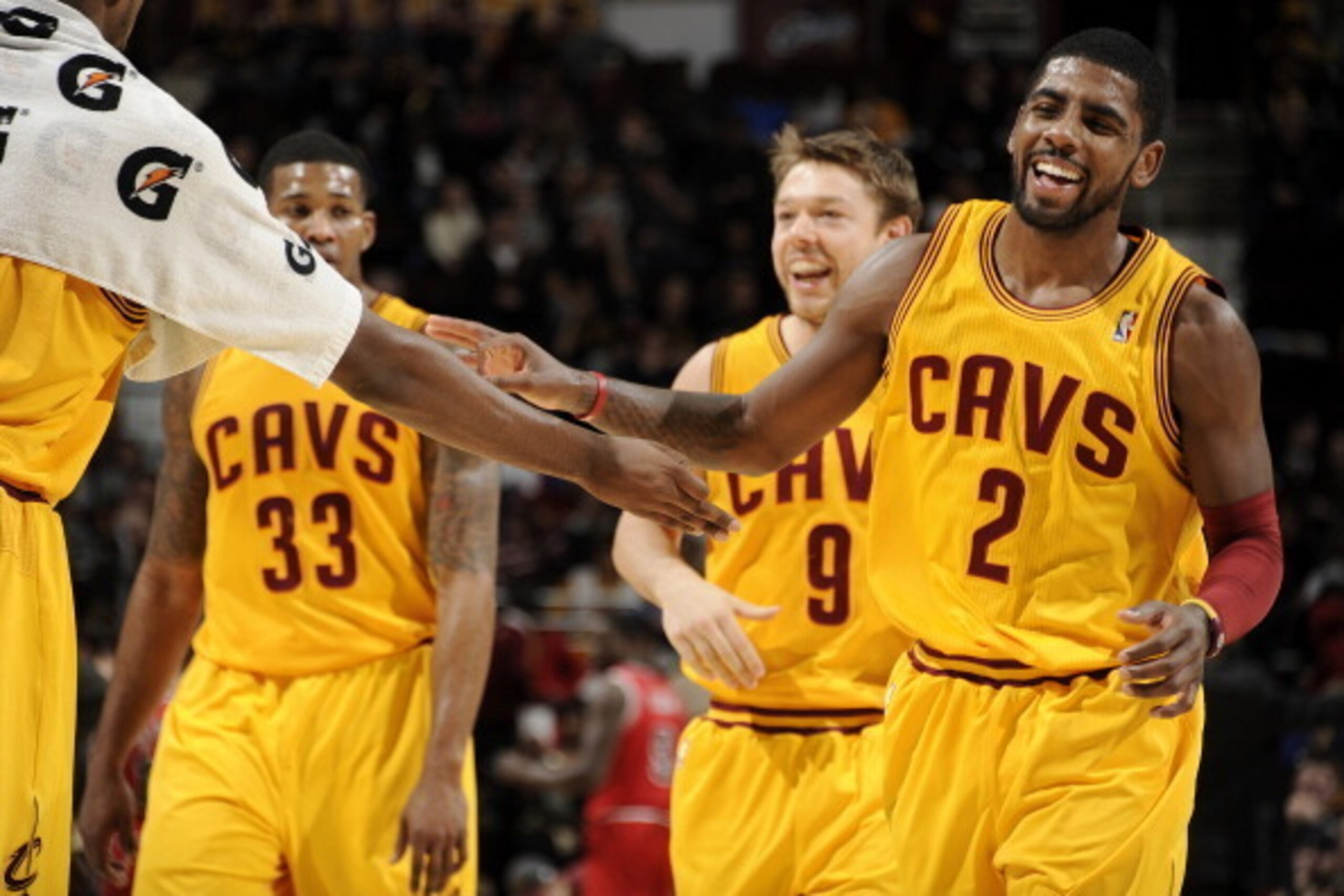 CLEVELAND, OH - NOVEMBER 30:  Kyrie Irving #2 of the Cleveland Cavaliers smiles wide as he is congratulated by teammates after sinking a three pointer against the Chicago Bulls at The Quicken Loans Arena on November 30, 2013 in Cleveland, Ohio. NOTE TO US