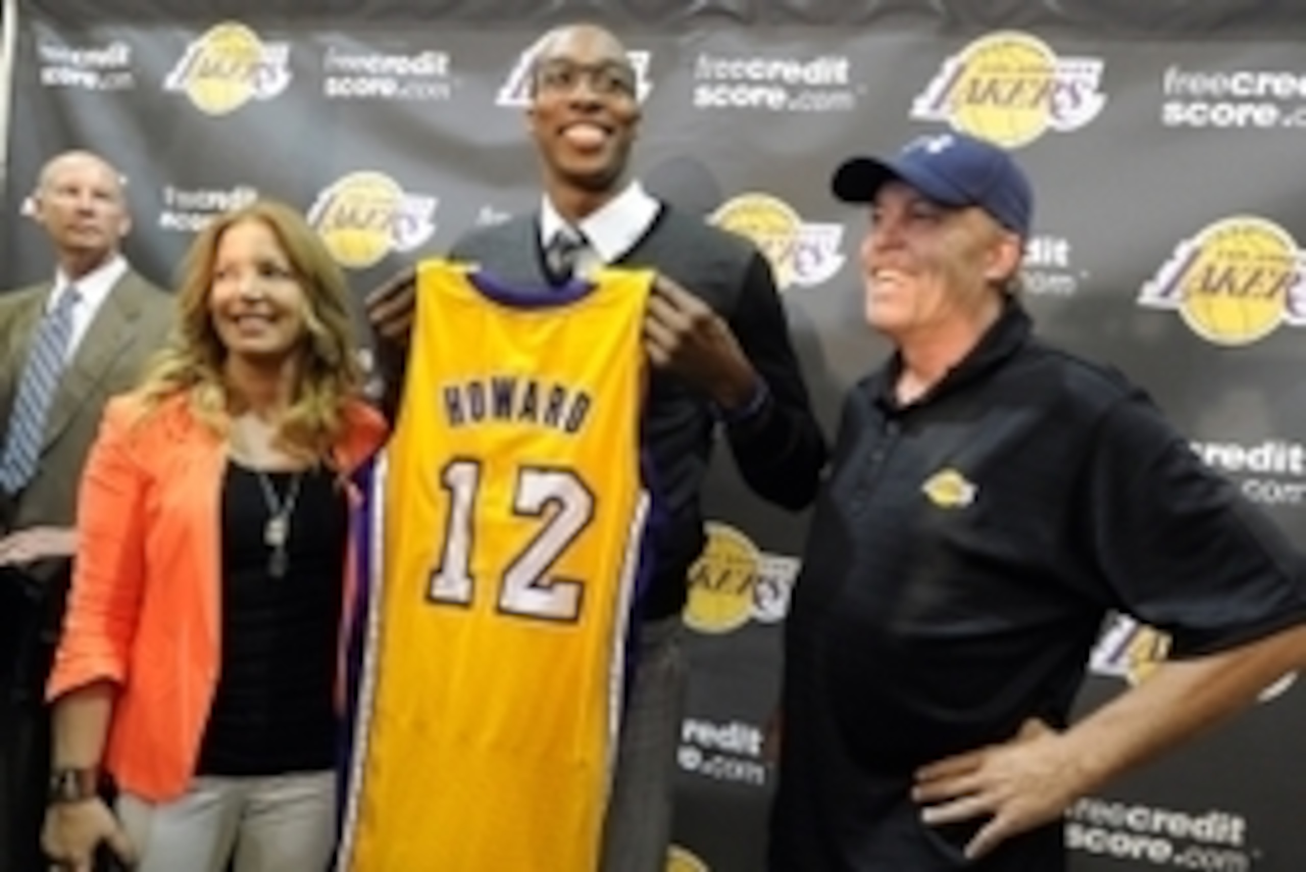 August 10, 2012; El Segundo, CA, USA;   Los Angeles Lakers center Dwight Howard stands between Jeanie Buss and Jim Buss as he holds his jersey during a press conference held to introduce the three-time defensive player of the year who was aquired in a fou