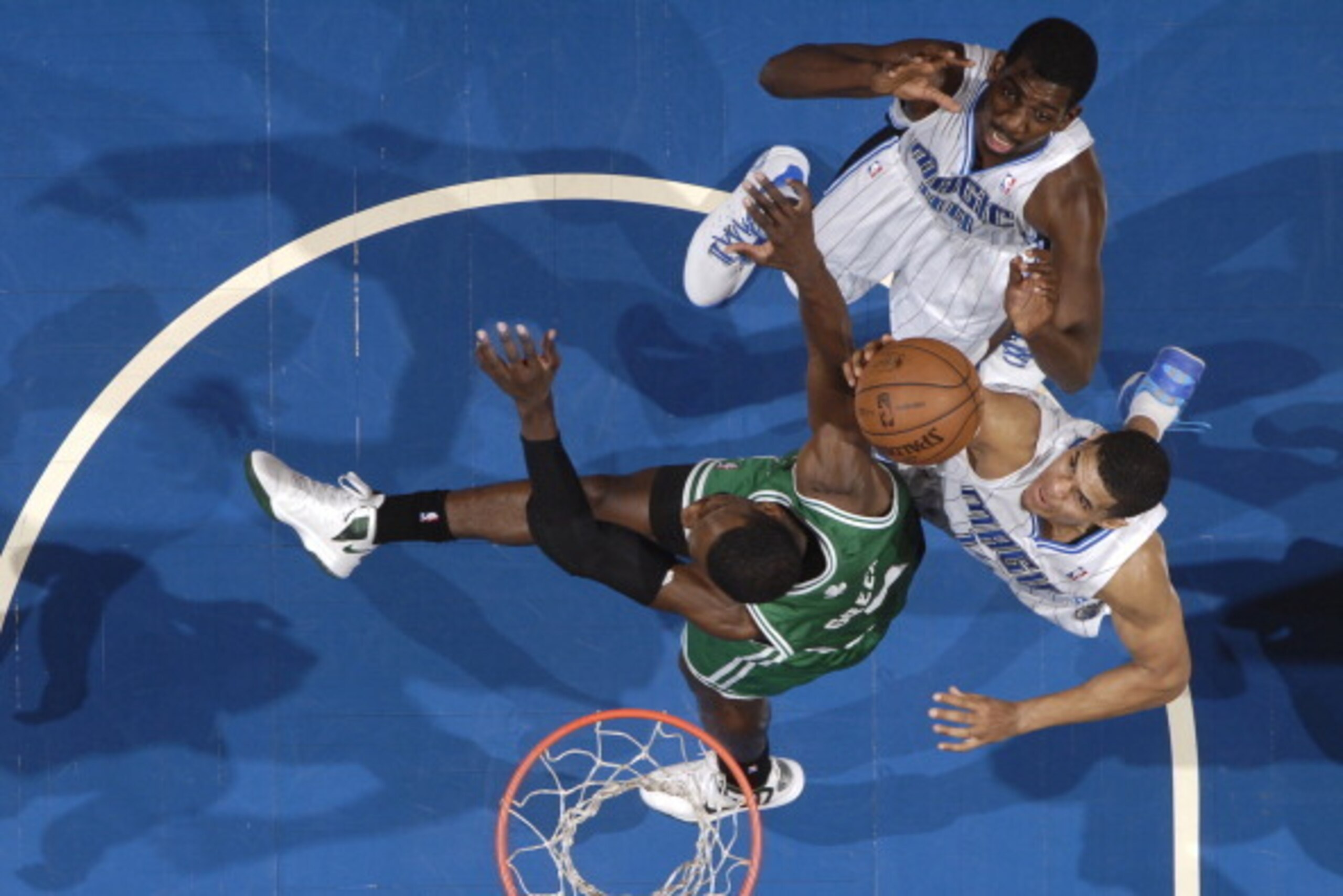 ORLANDO, FL - APRIL 13: Tobias Harris #12 of the Orlando Magic grabs a rebound against Jeff Green #8 of the Boston Celtics on April 13, 2013 at Amway Center in Orlando, Florida. NOTE TO USER: User expressly acknowledges and agrees that, by downloading and