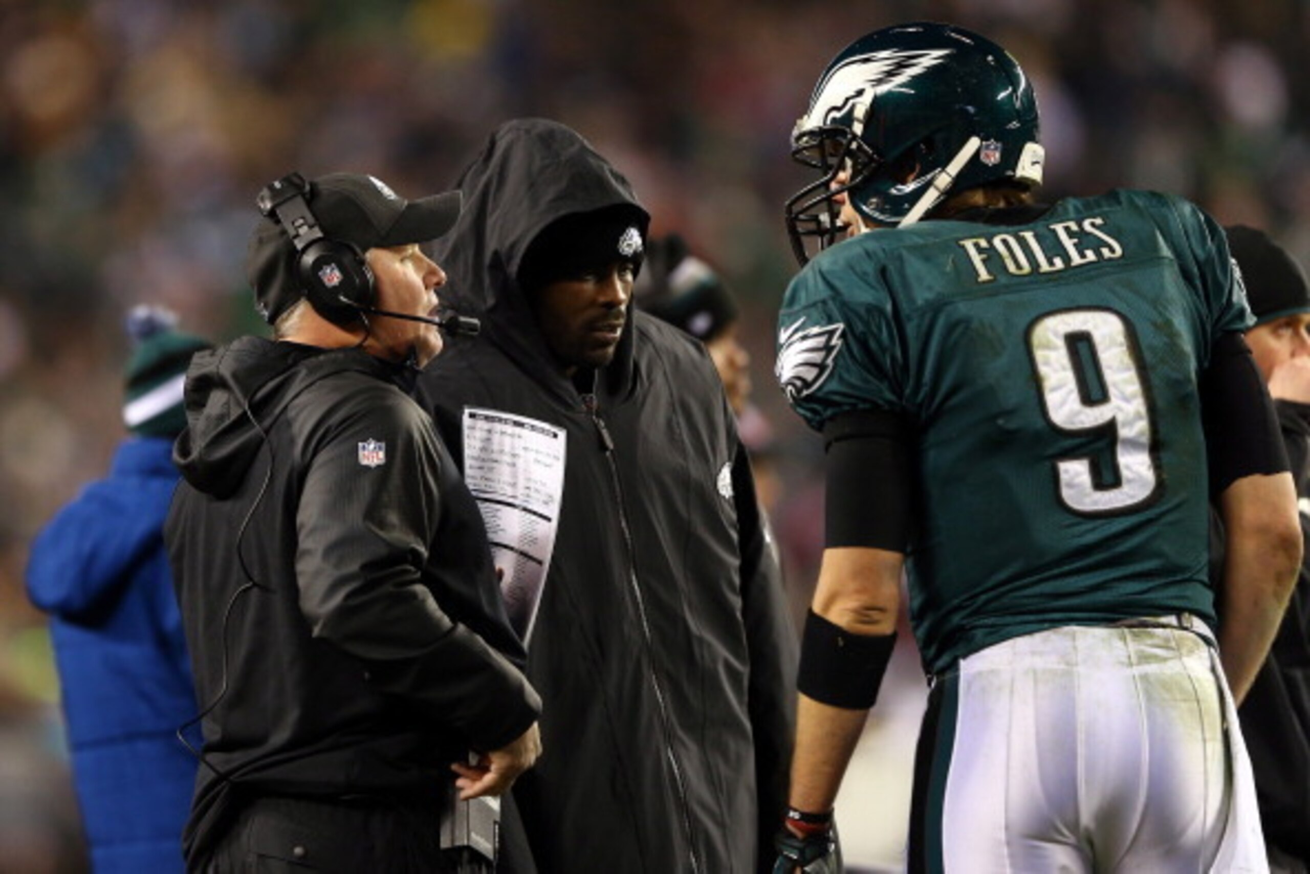 PHILADELPHIA, PA - JANUARY 04:   Nick Foles #9 of the Philadelphia Eagles talks with head coach Chip Kelly and teammate Michael Vick #7 on the sidelines against the New Orleans Saints during their NFC Wild Card Playoff game at Lincoln Financial Field on J