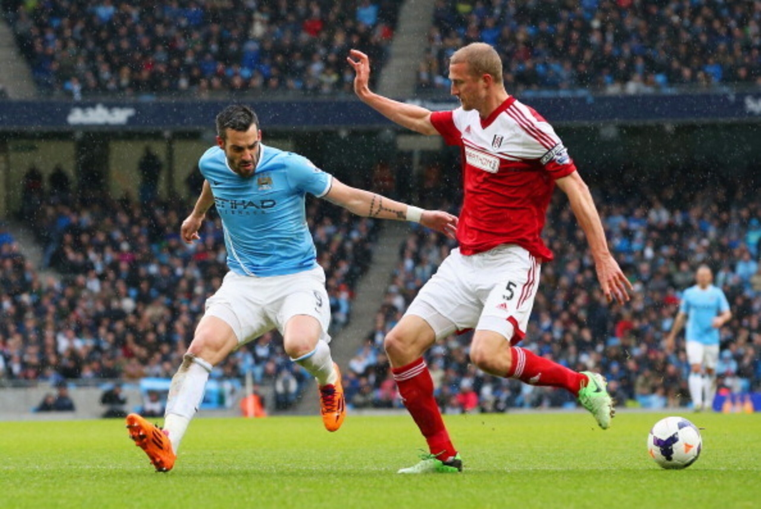 MANCHESTER, ENGLAND - MARCH 22: Alvaro Negredo of Manchester City and Brede Hangeland of Fulham compete for the ball during the Barclays Premier League match between Manchester City and Fulham at Etihad Stadium on March 22, 2014 in Manchester, England.  (