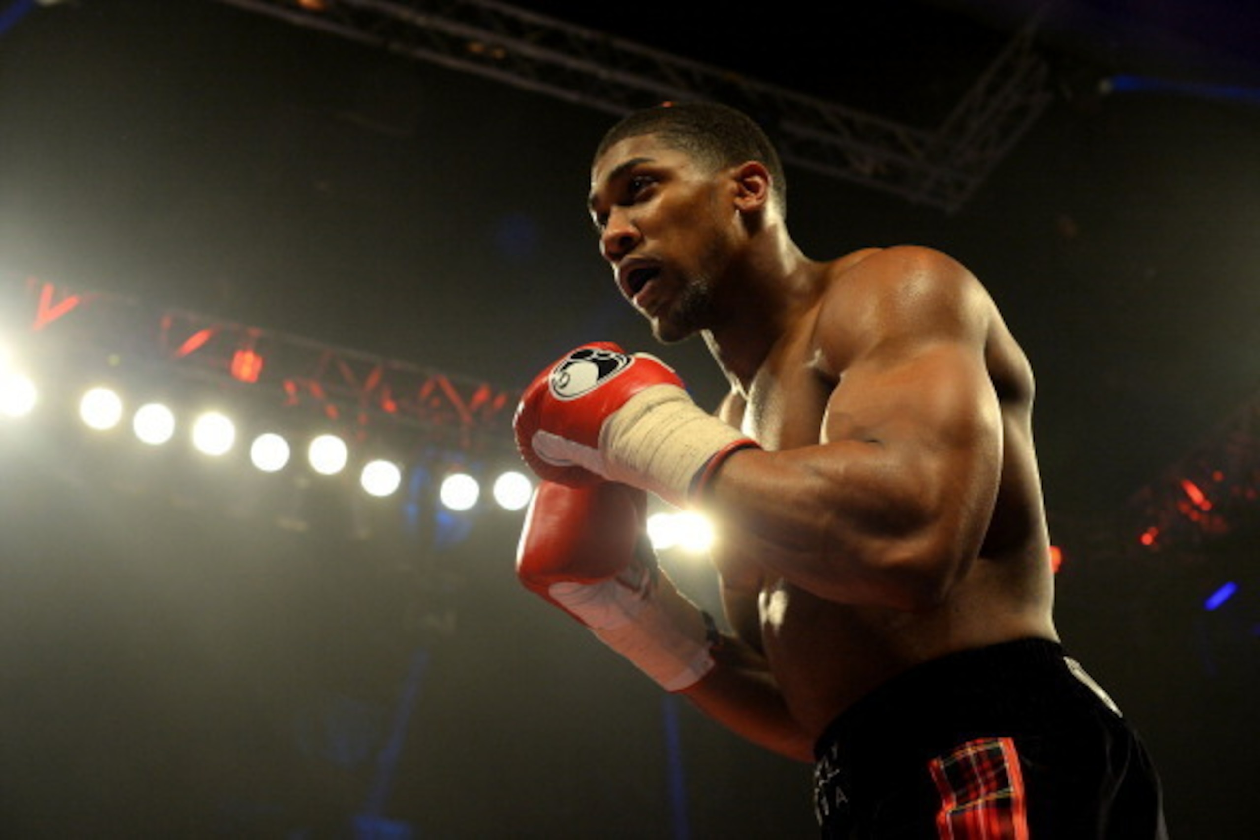 GLASGOW, SCOTLAND - MARCH 1 :  Anthony Joshua (black trunks) clashes with Hector Avila during an undercard bout at the WBO World Lightweight Championship Boxing match at the Glasgow SECC on March 1 2014 in Glasgow, Scotland. (Photo by Mark Runnacles/Getty