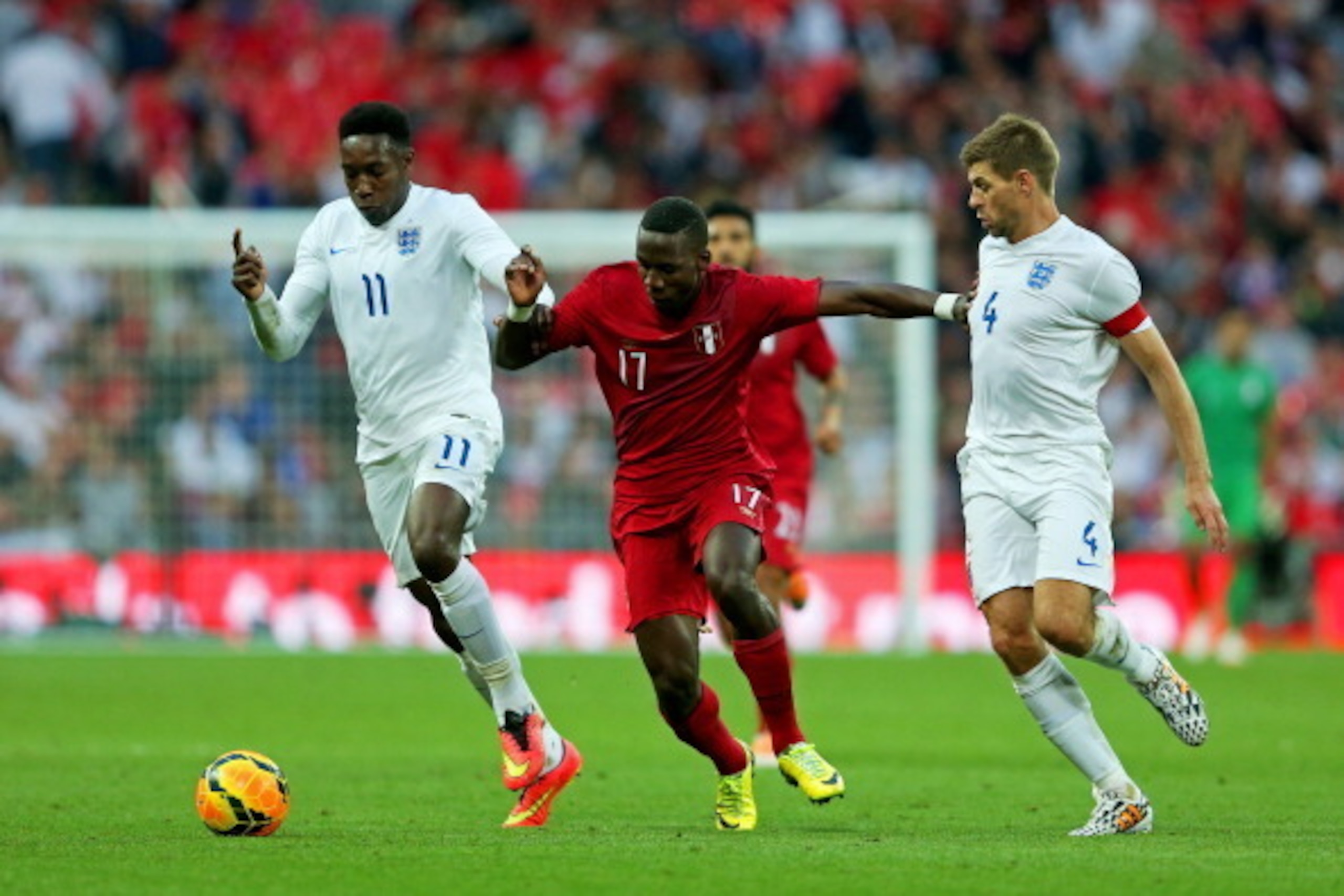 LONDON, ENGLAND - MAY 30:  Luis Advincula of Peru is closed down by Danny Welbeck and Steven Gerrard of England during the international friendly match between England and Peru at Wembley Stadium on May 30, 2014 in London, England.  (Photo by Warren Littl