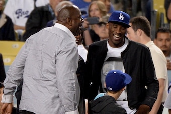 LOS ANGELES, CA - JULY 31:  Kobe Bryant of the Los Angeles Lakers and Magic Johnson laugh during the game against the New York Yankees at Dodger Stadium on July 31, 2013 in Los Angeles, California.  (Photo by Harry How/Getty Images)