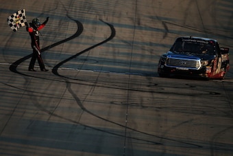 DOVER, DE - MAY 30:  Kyle Busch, driver of the #51 Betty Jane France Humanitarian Award Toyota, celebrates with the checkered flag after winning the NASCAR Camping World Truck Series Lucas Oil 200 at Dover International Speedway on May 30, 2014 in Dover, 