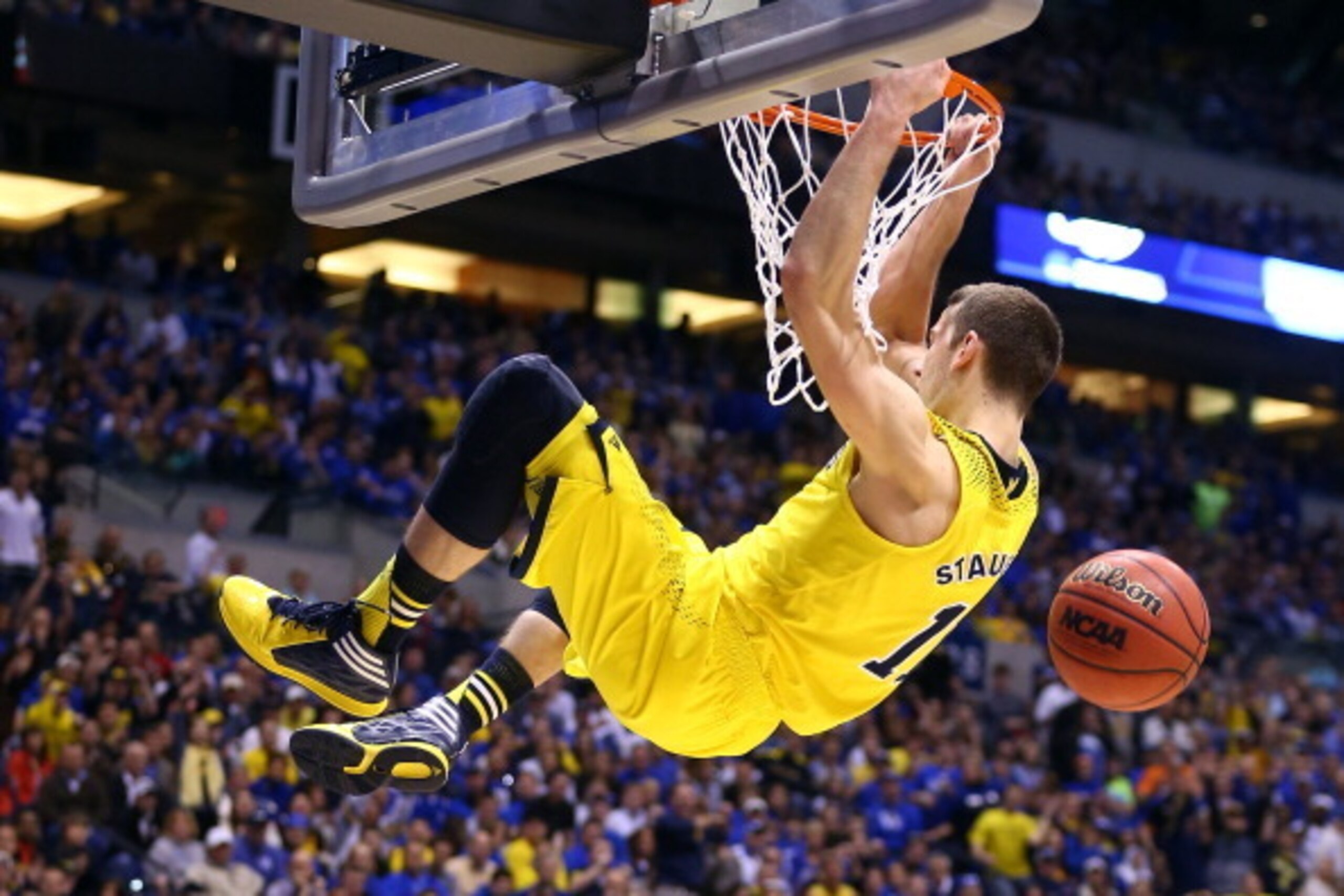 INDIANAPOLIS, IN - MARCH 30:  Nik Stauskas #11 of the Michigan Wolverines dunks the ball over Dominique Hawkins #25 of the Kentucky Wildcats in the second half during the midwest regional final of the 2014 NCAA Men's Basketball Tournament at Lucas Oil Sta