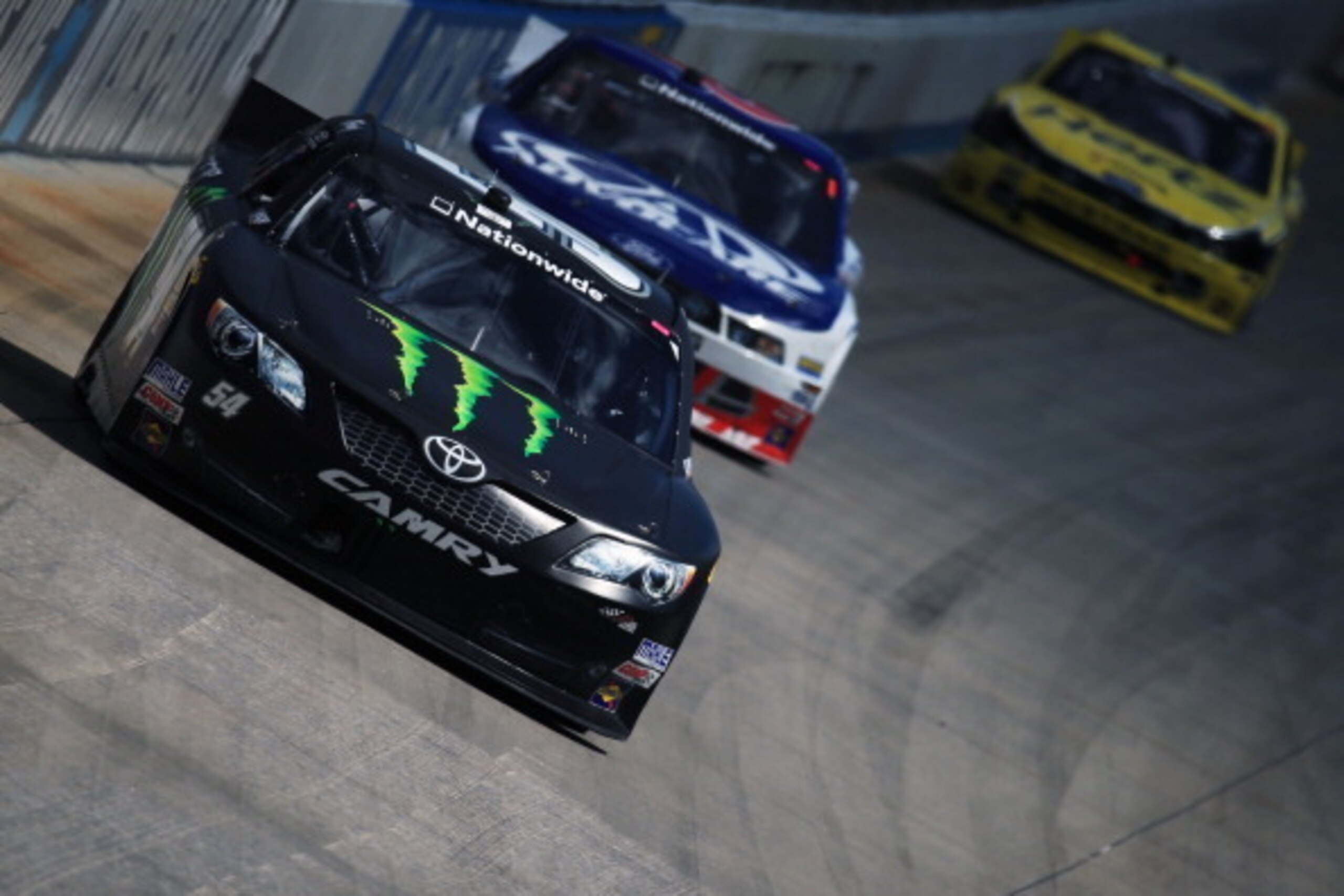 DOVER, DE - MAY 31:  Kyle Busch, driver of the #54 Monster Energy Toyota, leads Trevor Bayne, driver of the #6 AdvoCare Ford, and Joey Logano, driver of the #22 Hertz Ford, during the NASCAR Nationwide Series Buckle Up 200 Presented By Click It Or Ticket 
