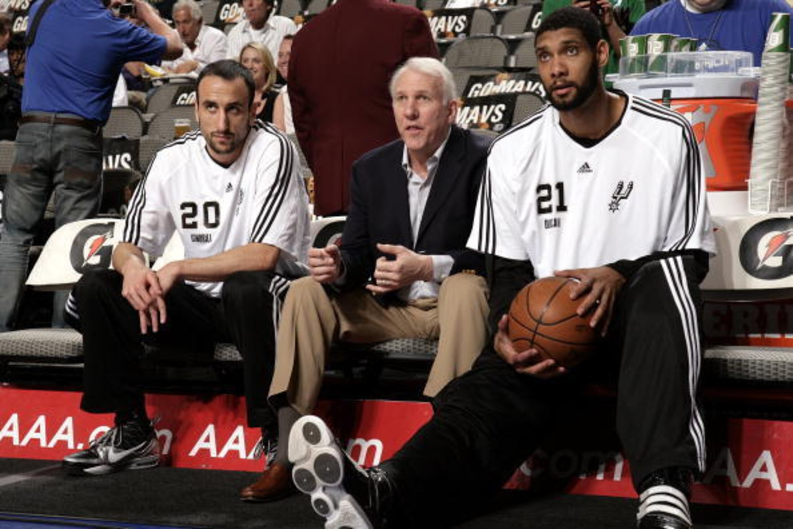 DALLAS - APRIL 14:  Manu Ginobili #20, head coach Gregg Popovich and Tim Duncan #21 of the San Antonio Spurs sit on the bench during warm-ups prior to the game against the Dallas Mavericks at American Airlines Center on April 14, 2010 in Dallas, Texas.  T