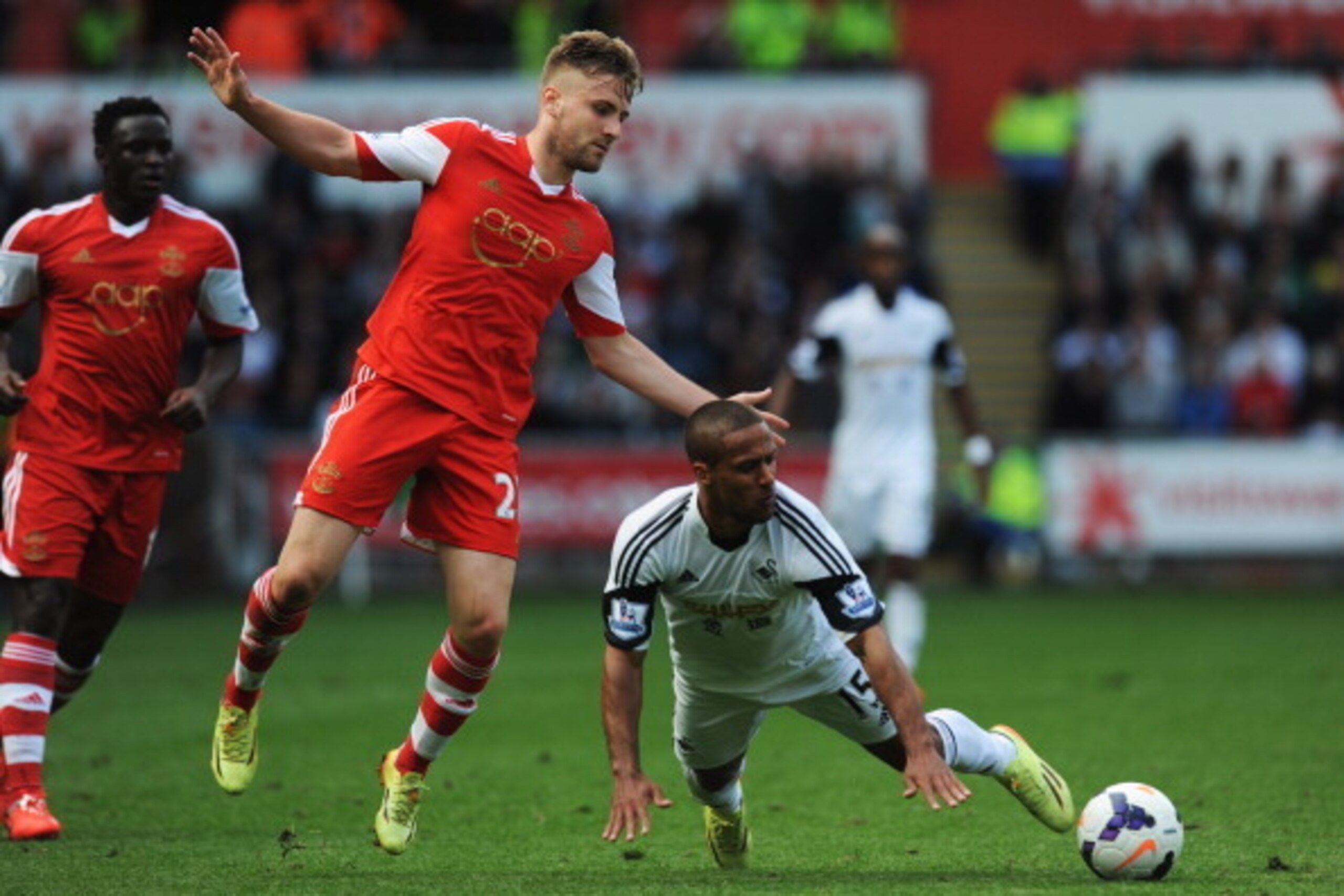 SWANSEA, WALES - MAY 03:  Wayne Routledge of Swansea City takes on Luke Shaw and Victor Wanyama of Southampton during the Barclays Premier League match between Swansea City and Southampton at Liberty Stadium on May 3, 2014 in Swansea, Wales.  (Photo by St