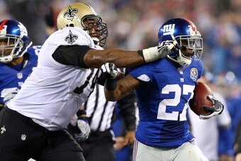 EAST RUTHERFORD, NJ - DECEMBER 09:  Stevie Brown #27 of the New York Giants is shoved out of bounds by Jermon Bushrod #74 of the New Orleans Saints on December 9, 2012 at MetLife Stadium in East Rutherford, New Jersey.  (Photo by Elsa/Getty Images)