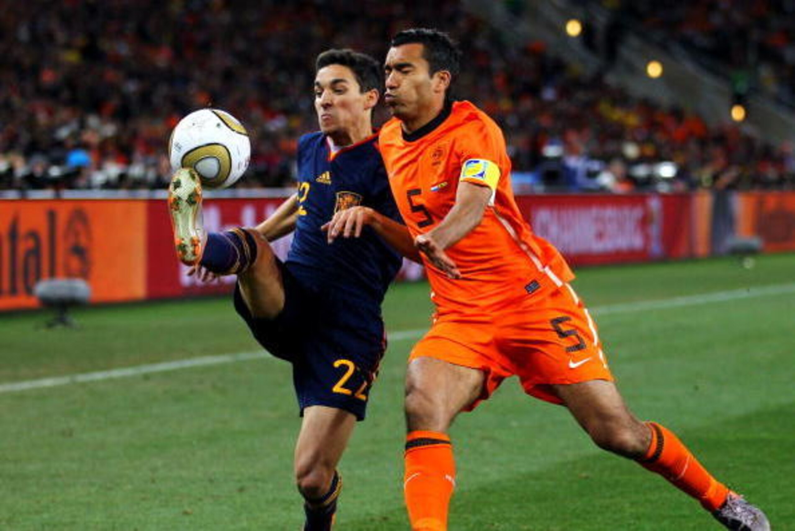 JOHANNESBURG, SOUTH AFRICA - JULY 11: Jesus Navas of Spain and Giovanni Van Bronckhorst of the Netherlands battle for the ball during the 2010 FIFA World Cup South Africa Final match between Netherlands and Spain at Soccer City Stadium on July 11, 2010 i JOHANNESBURG, SOUTH AFRICA - JULY 11: Jesus Navas of Spain and Giovanni Van Bronckhorst of the Netherlands battle for the ball during the 2010 FIFA World Cup South Africa Final match between Netherlands and Spain at Soccer City Stadium on July 11, 2010 i