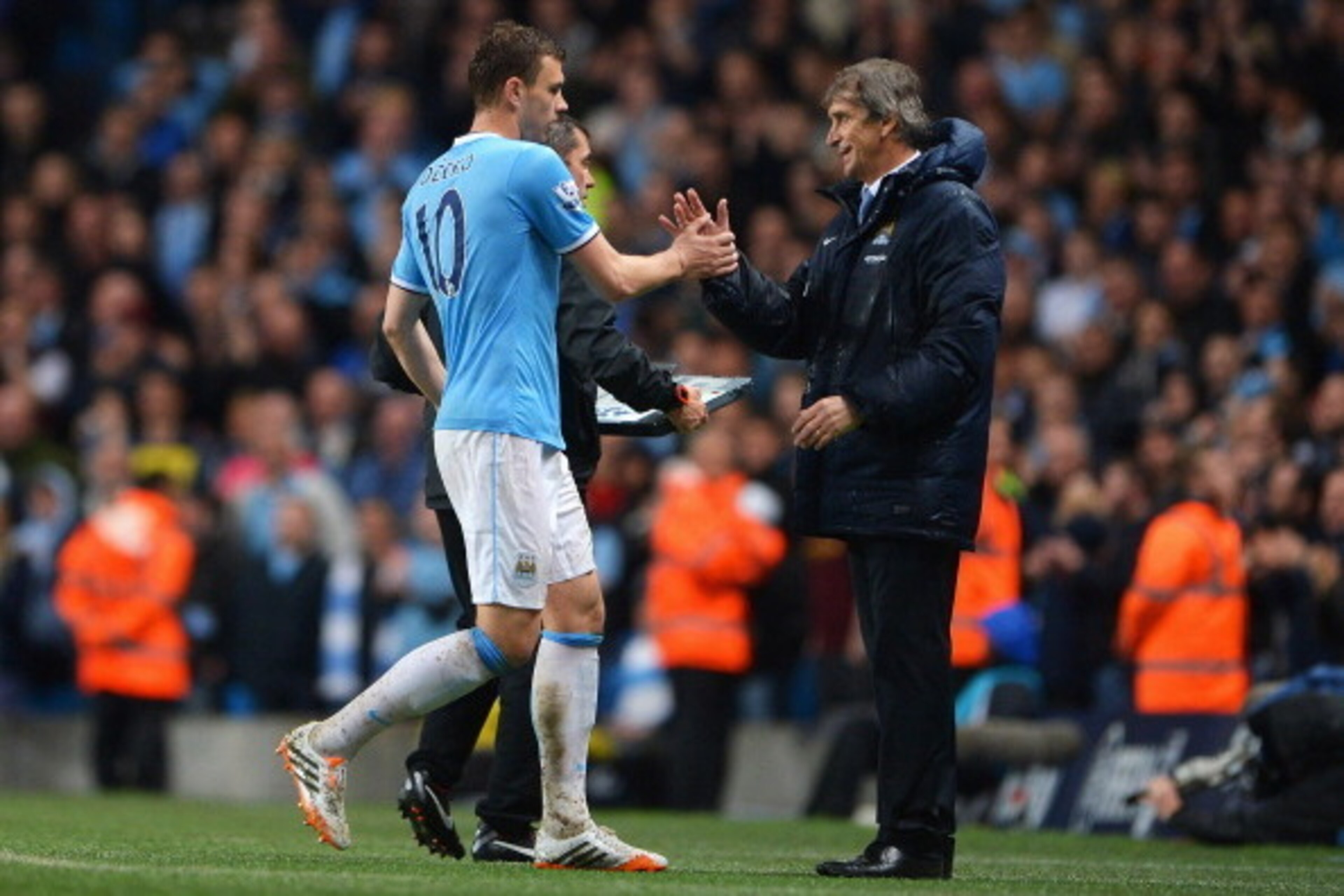 MANCHESTER, ENGLAND - MAY 07:  Edin Dzeko of Manchester City is congratulated by Manuel Pellegrini, manager of Manchester City as he is substituted during the Barclays Premier League match between Manchester City and Aston Villa at Etihad Stadium on May 7