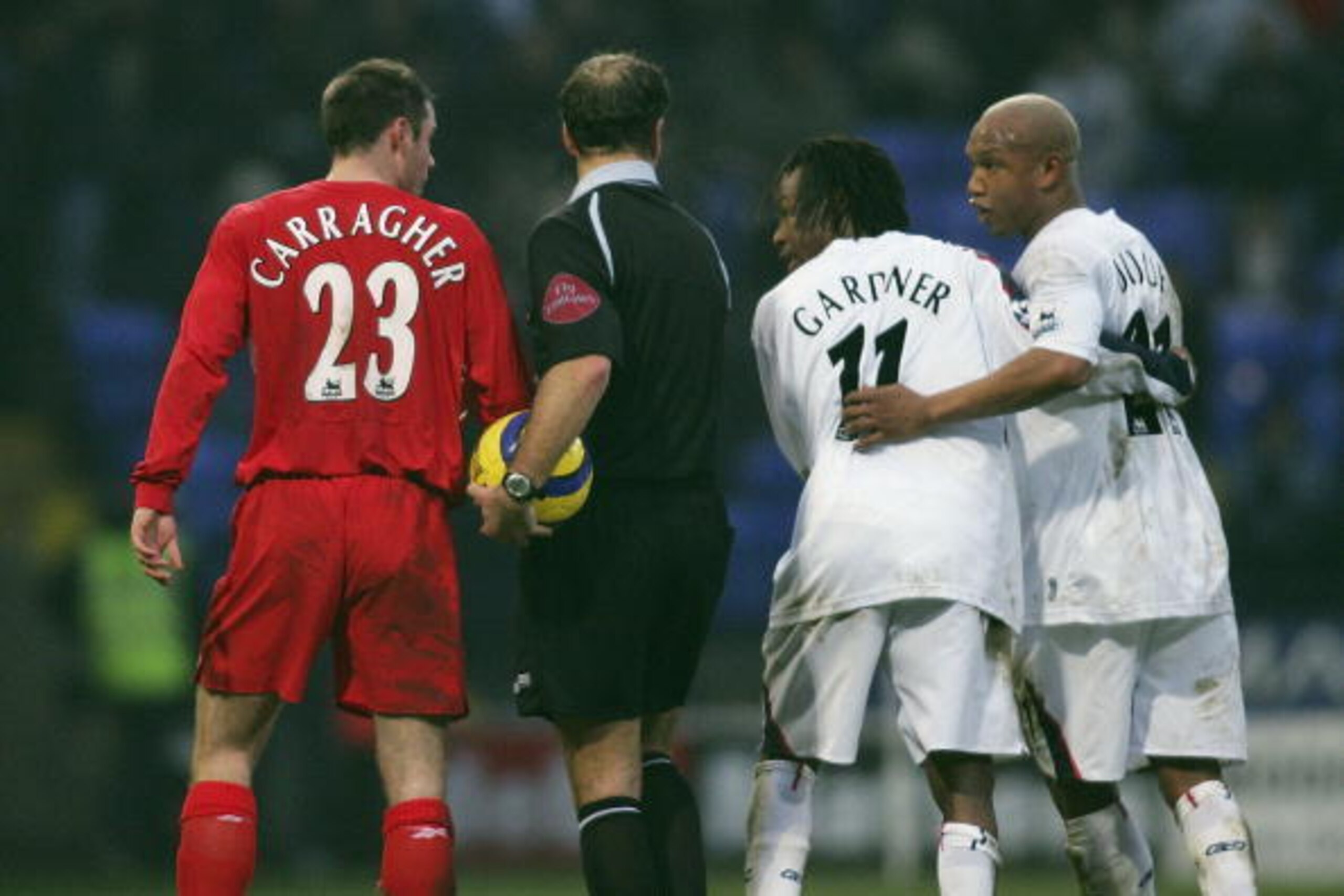 BOLTON, ENGLAND - JANUARY 2 : El-Hadji Diouf (right) of Bolton is kept apart from Jamie Carragher of Liverpool (left) by Ricardo Gardner and referee Mark Clattenburg during the Barclays Premiership match between Bolton Wanderers and Liverpool at the Reebo