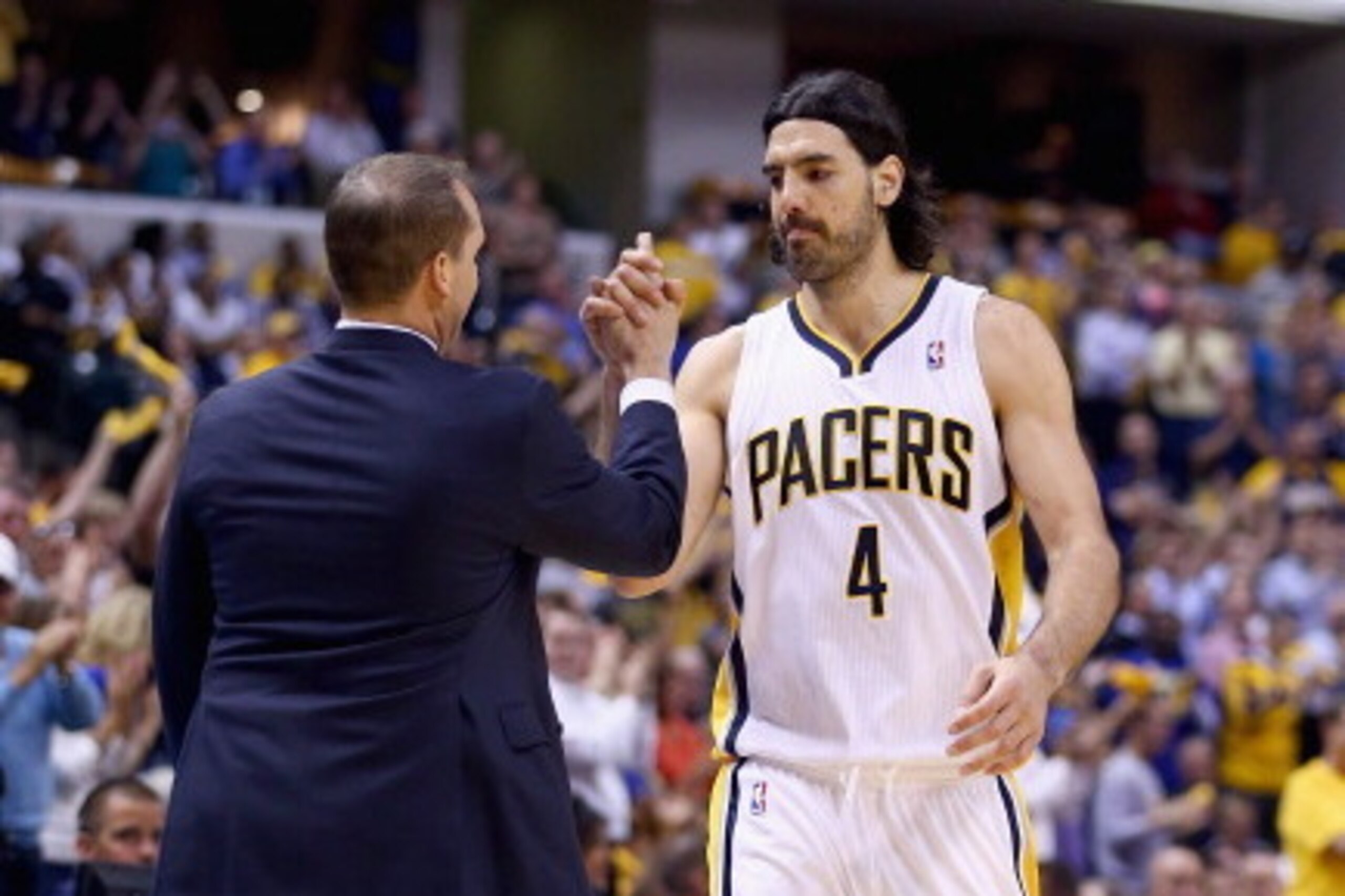 INDIANAPOLIS, IN - APRIL 22:  Frank Vogel the head coach of the Indiana Pacers congratulates Luis Scola #4 as he leaves the game in the final minutes of the 101-85 won over the Atlanta Hawks in Game 2 of the Eastern Conference Quarterfinals during the 201
