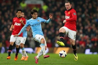 MANCHESTER, ENGLAND - MARCH 25:  David Silva of Manchester City competes with Wayne Rooney of Manchester United during the Barclays Premier League match between Manchester United and Manchester City at Old Trafford on March 25, 2014 in Manchester, England