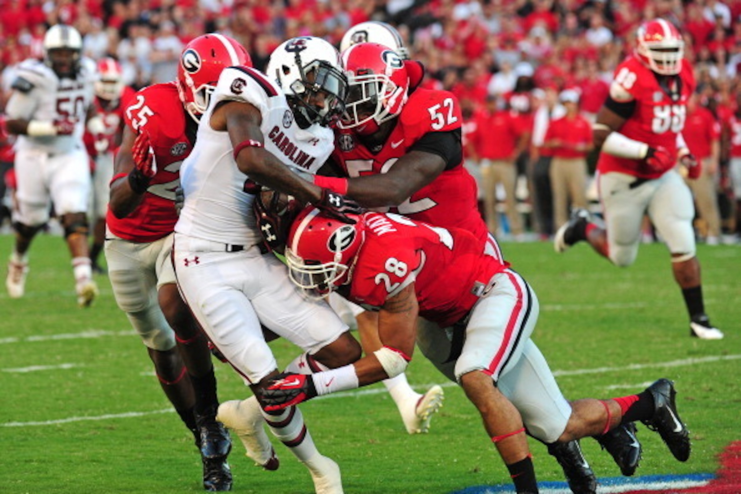 ATHENS, GA - SEPTEMBER 7: Shaq Roland #4 of the South Carolina Gamecocks is tackled by Tray Matthews #28, Amarlo Herrera #52 and Josh Harvey-Clemons #25 of the Georgia Bulldogs at Sanford Stadium on September 7, 2013 in Athens, Georgia. (Photo by Scott Cu