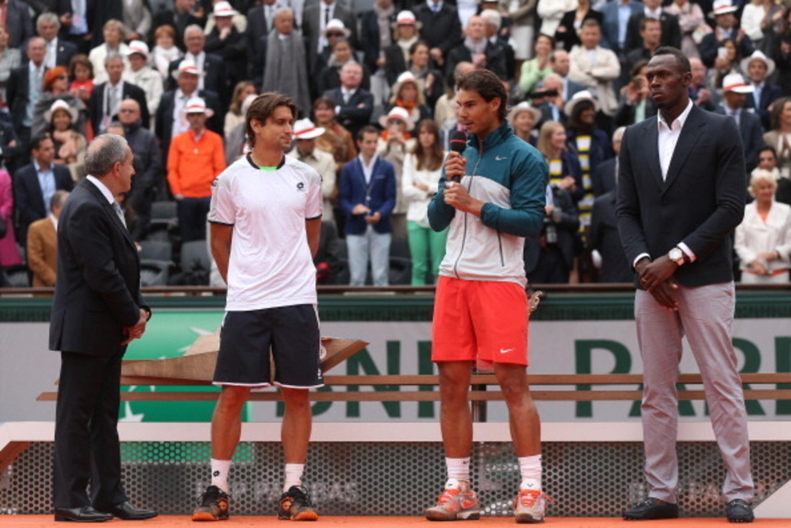 PARIS, FRANCE - JUNE 09:  Rafael Nadal of Spain speaks to the crowd next to David Ferrer of Spain, Olympic champion Usain Bolt and President of the International Tennis Federation Francesco Bitti Ricci as he celebrates victory in the men's singles final a