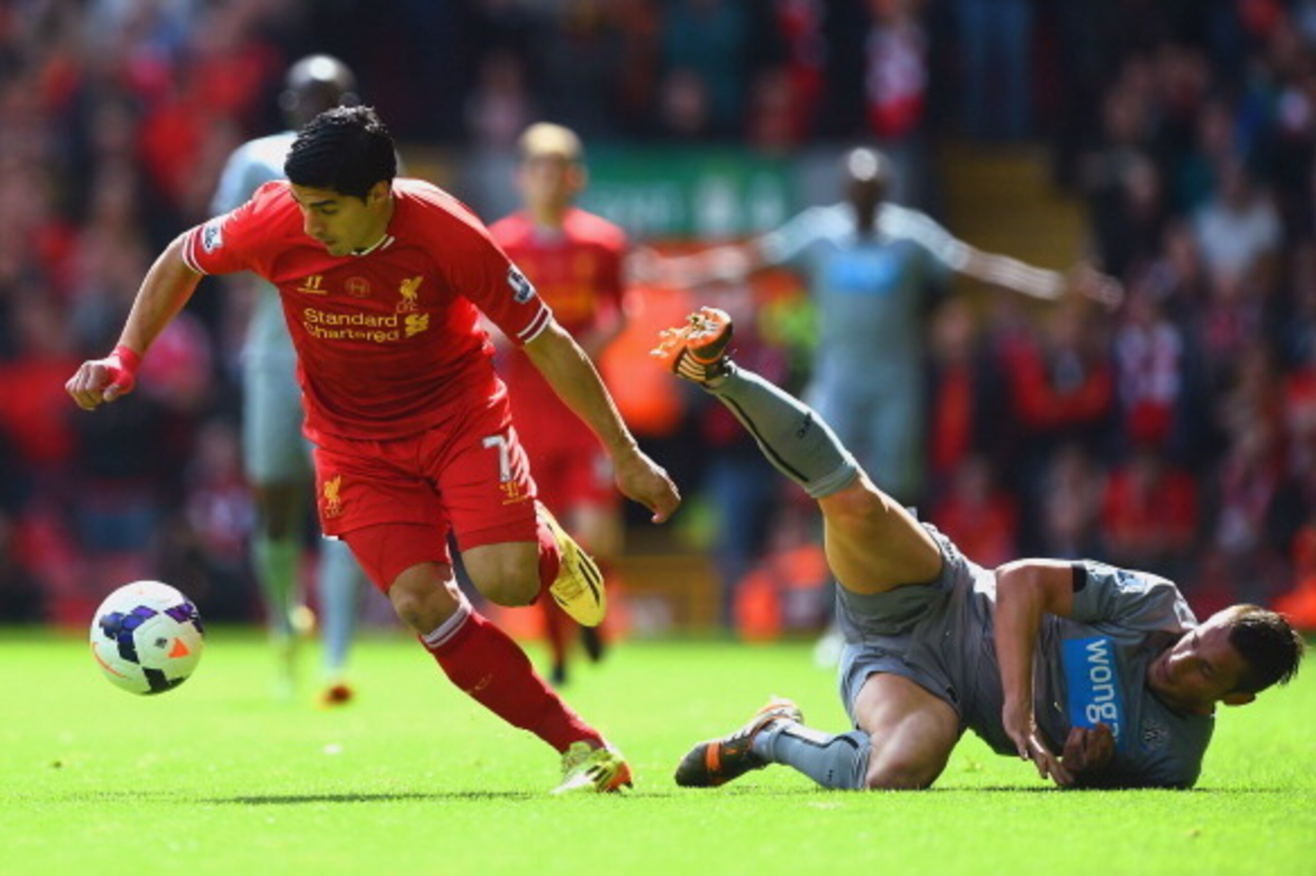 LIVERPOOL, ENGLAND - MAY 11:  Luis Suarez of Liverpool evades Mathieu Debuchy of Newcastle United during the Barclays Premier League match between Liverpool and Newcastle United at Anfield on May 11, 2014 in Liverpool, England.  (Photo by Laurence Griffit