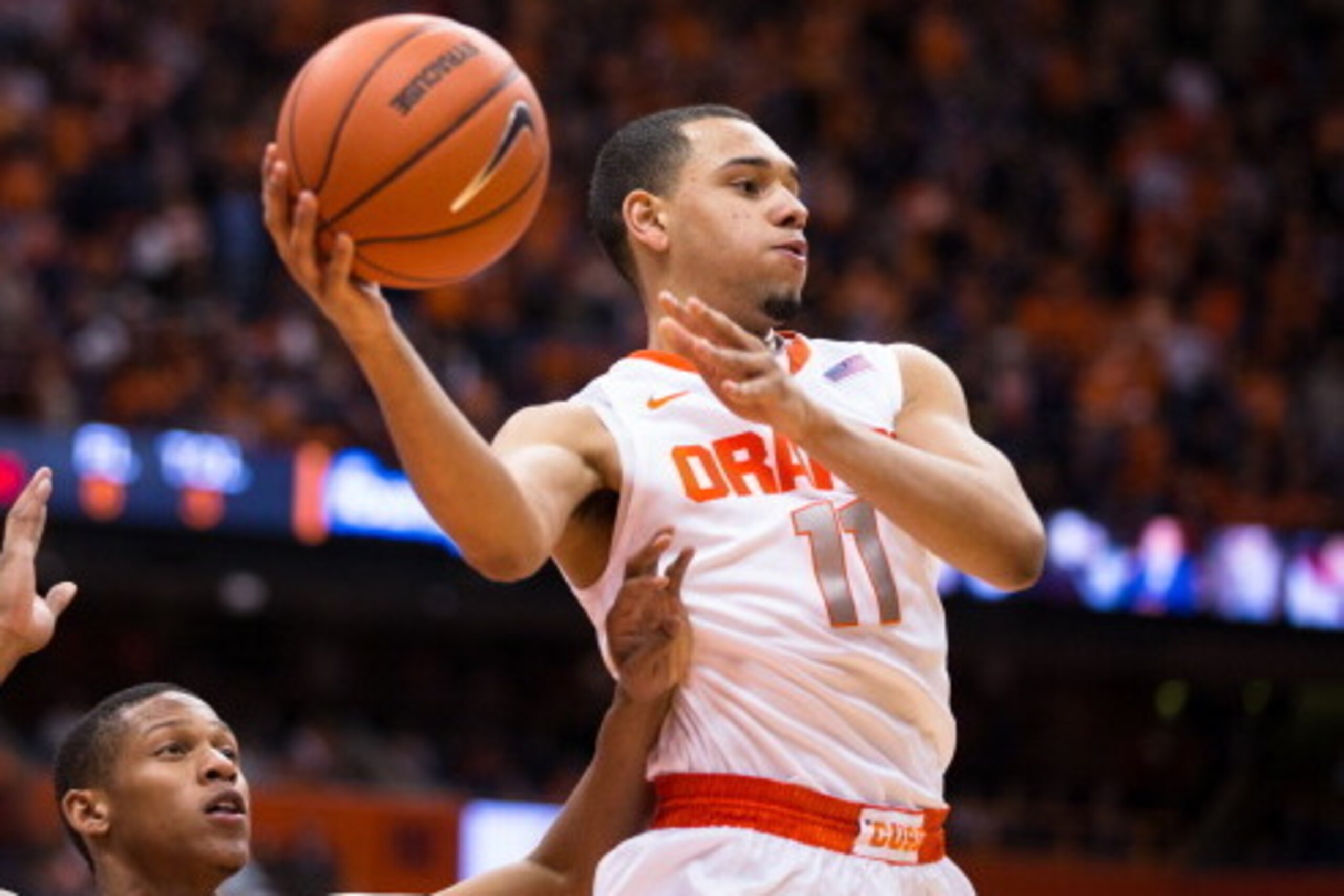 SYRACUSE, NY - FEBRUARY 9:  Tyler Ennis #11 of the Syracuse Orange makes a jumping pass while being defended by Jaron Blossomgame #5 of the Clemson Tigers during the second half on February 9, 2014 at The Carrier Dome in Syracuse, New York.  Syracuse defe